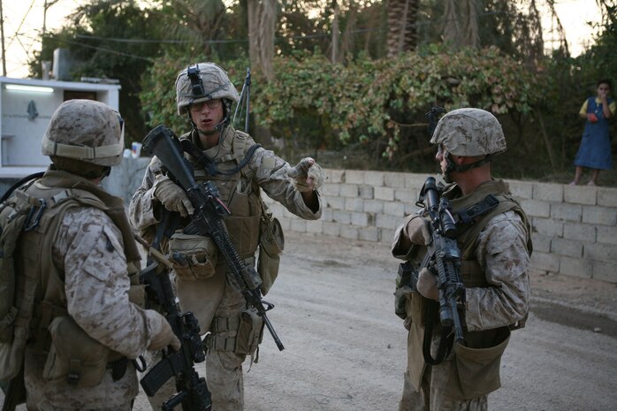Cpl. Brian Roarke (center), a team leader with 1st Platoon, Fox Company, 2nd Battalion, 2nd Marine Regiment, Regimental Combat Team 5, shows Sgt Dante Sevieri (right), a squad leader, and Staff Sgt. Jaime Benevides, platoon sergeant, both with Provisional Rifle Platoon 3, RCT-5, where there are people who have supported insurgents in the past, while on a patrol in Rawah, Iraq, Oct. 10.  Marines with PRP 3 assumed control of two traffic control points from 1st Platoon, Fox Co.::r::::n::
