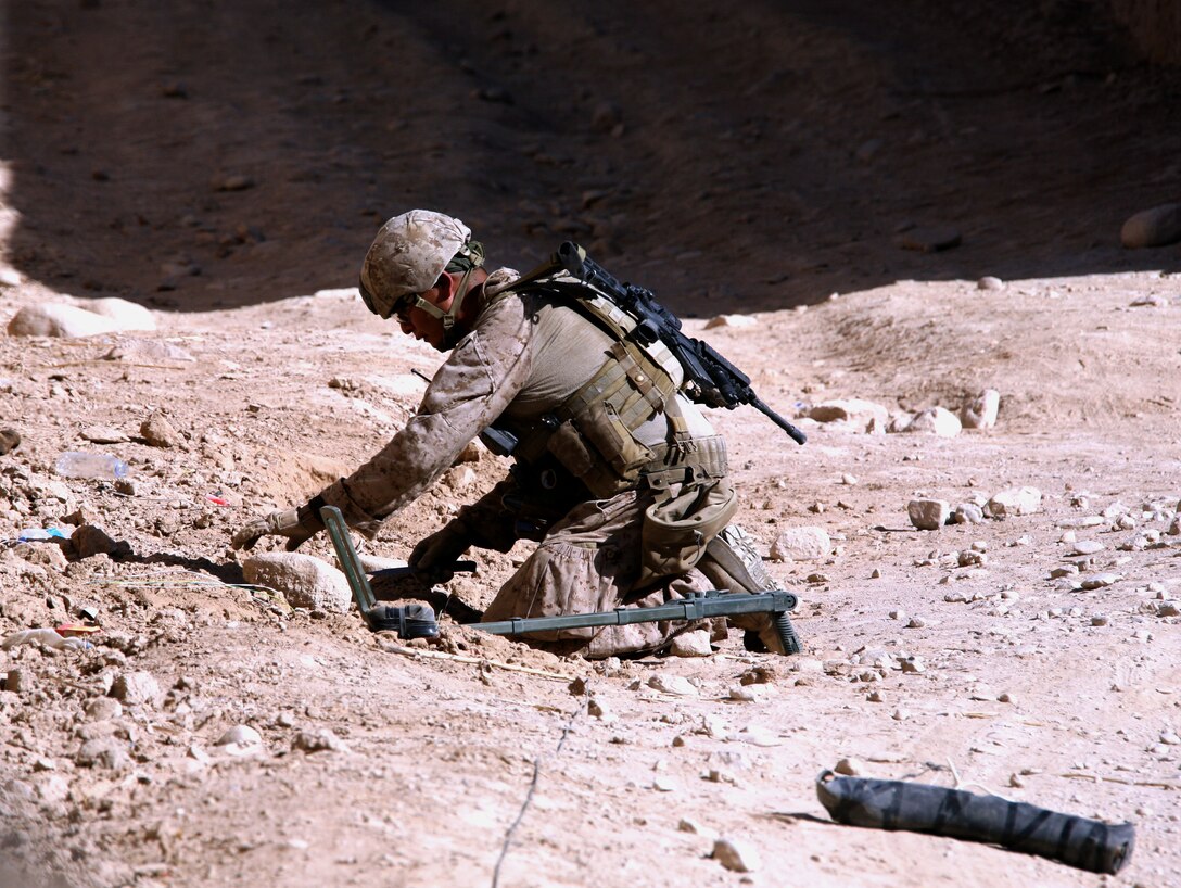 HELMAND PROVINCE, Forward Operating Base Sangin, Afghanistan – Staff Sgt. Hoskie T. Attson, an Explosive Ordnance Disposal (EOD) technician, assigned to Company E, Task Force 2d Battalion, 7th Marine Regiment, Special Purpose Marine Air Ground Task Force Afghanistan, and Farmington, N.M., native, cautiously uncovers the components of an improvised explosive device (IED) near Patrol Base Wishton in the Sangin District Center, Oct. 9.  The EOD Marines assigned to Echo Company have responded to more than 100 IEDs during their six months of operating in the Sangin area.  Task Force 2/7 Marines have successfully adapted to defeating increasingly more complex IEDs, including some specifically designed to target the EOD Marines. (U.S. Marine Corps photo by Sgt. Steve Cushman)