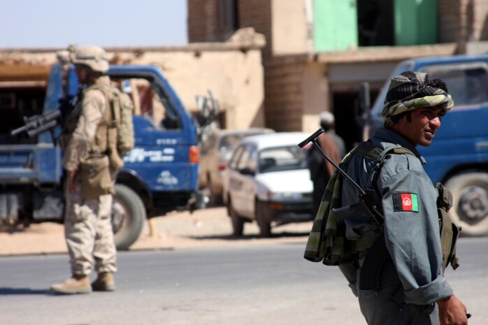 An Afghan National Policeman and a Marine assigned to Company G, Task Force 2d Battalion, 7th Marine Regiment, Special Purpose Marine Air Ground Task Force Afghanistan, monitors traffic during a patrol in Bala Baluk.