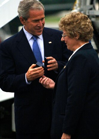 President George Bush presents the President's Volunteer Service Award to Eileen Hadbavny on the Charleston Air Force Base, S.C., flightline Oct. 10. President Bush met with more than 250 Team Charleston members en route to an event at Kiawah Island, S.C. Ms. Hadbavny is with the American Red Cross and is a former member of the 315th Airlift Wing here. (U.S. Air Force photo/Airman 1st Class Timothy Taylor)