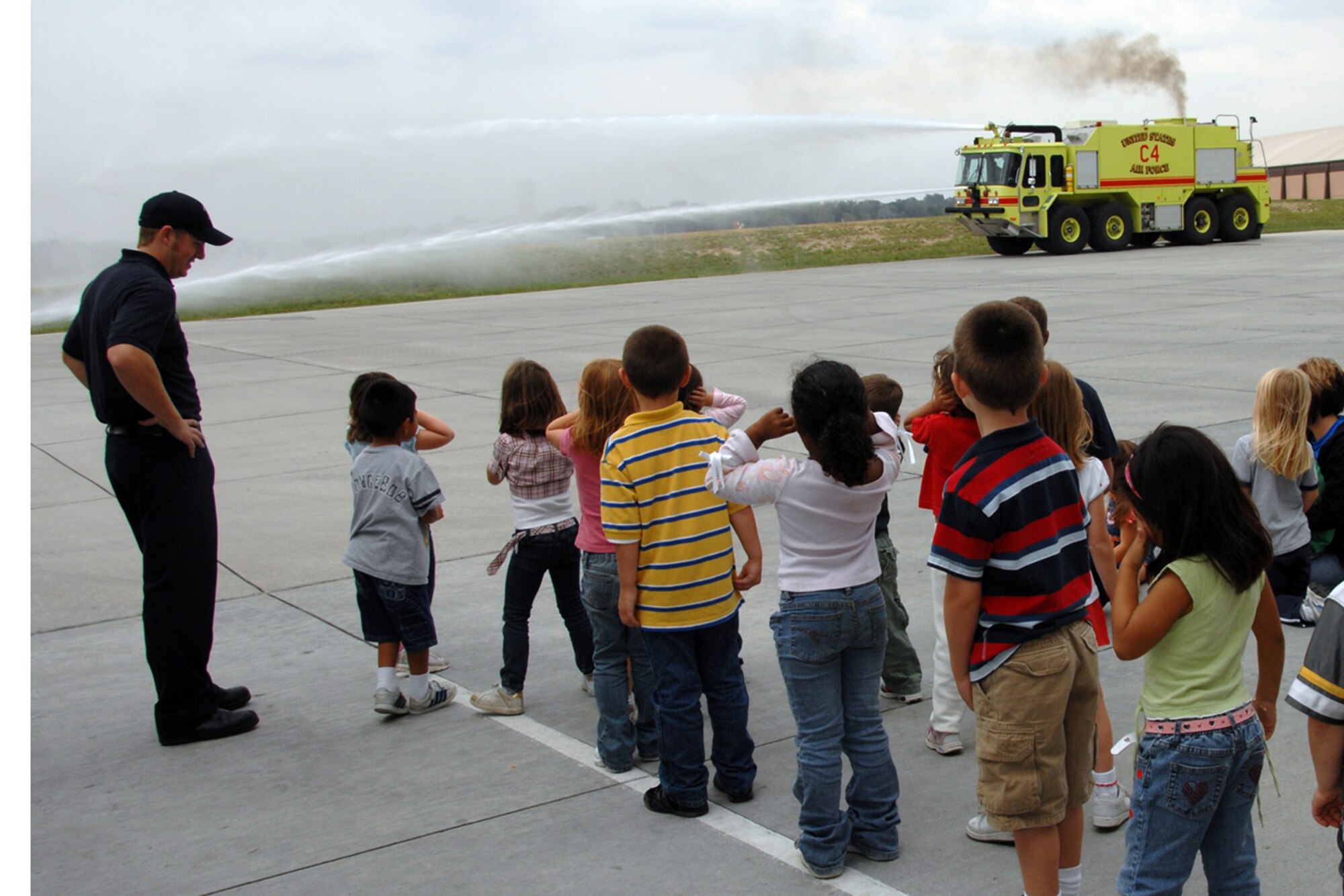 OFFUTT AIR FORCE BASE, Neb. -- Birchcrest Elementary students look on as Offutt fire fighters demonstrate how a fire truck could be used to extinguish a fire Oct. 8. Members of the Offutt Fire Station gave tours to more than 1,000 students this week as part of National Fire Prevention Week. (U.S. Air Force Photo By Kendra Williams)