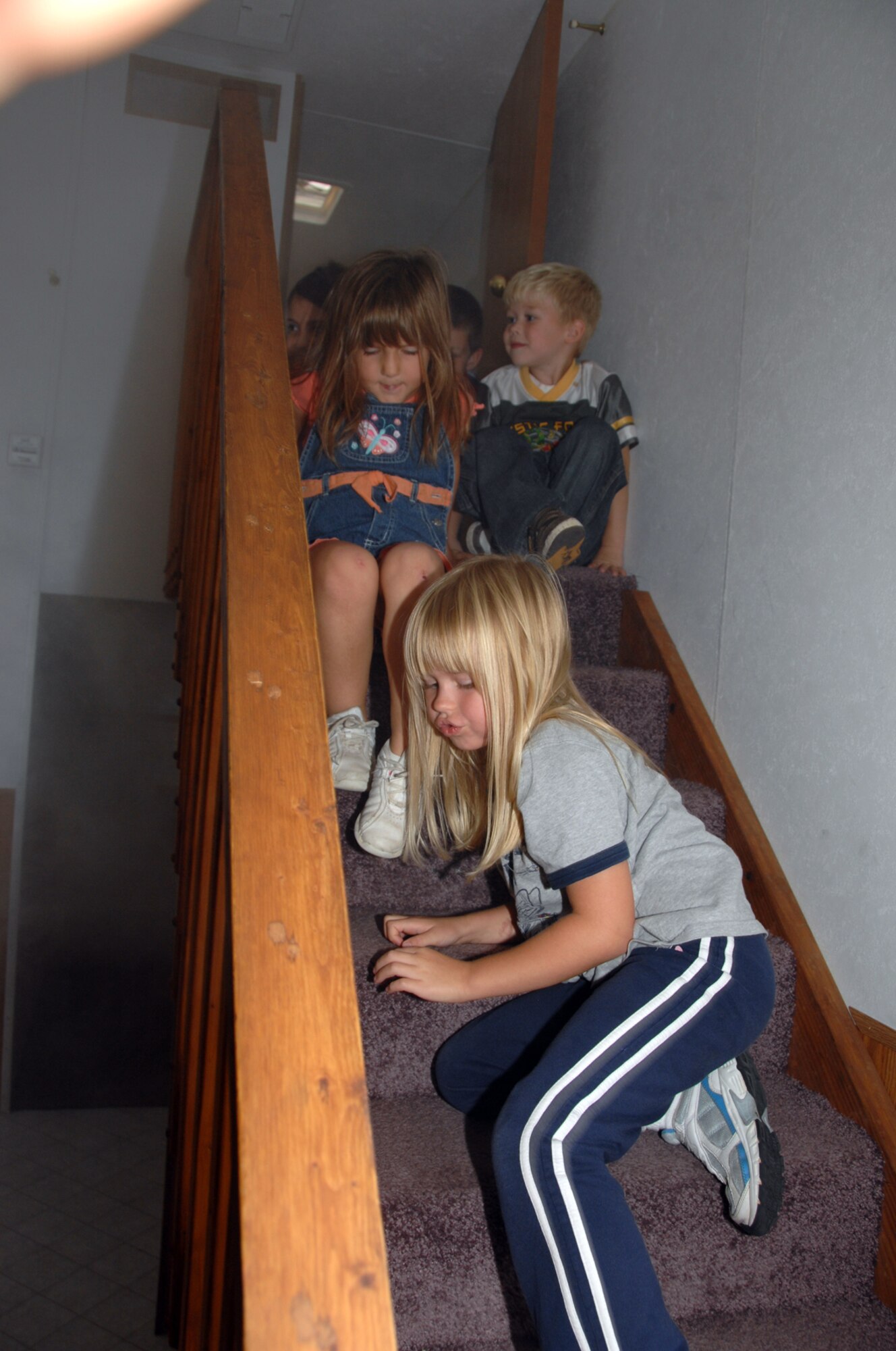 OFFUTT AIR FORCE BASE, Neb. -- Kindergarten students from Birchcrest Elementary school demonstrate crawling on the floor to an exit in the fire safety house Oct. 8 to simulate what to do in case of a fire. Members of the Offutt Fire Station gave tours to more than 1,000 students this week as part of National Fire Prevention Week. (U.S. Air Force Photo By Kendra Williams)