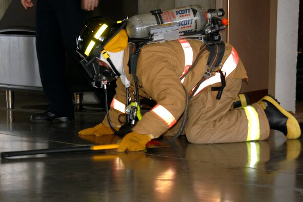 OFFUTT AIR FORCE BASE, Neb. -- Firefighter Tommy Schroeder, 55 Civil Engineer Squadron fire protection, demonstrates what a firefighter would look like coming into a smoke filled house. Members of the Offutt Fire Station gave a tour to Birchcrest Elementary school students Oct. 8 as part of Offutt’s participation in National Fire Prevention Week. Mr. Schroeder gave this demonstration to kindergarten students so they will not be afraid of emergency responders if they are ever in a real fire. (U.S. Air Force Photo By Kendra Williams)