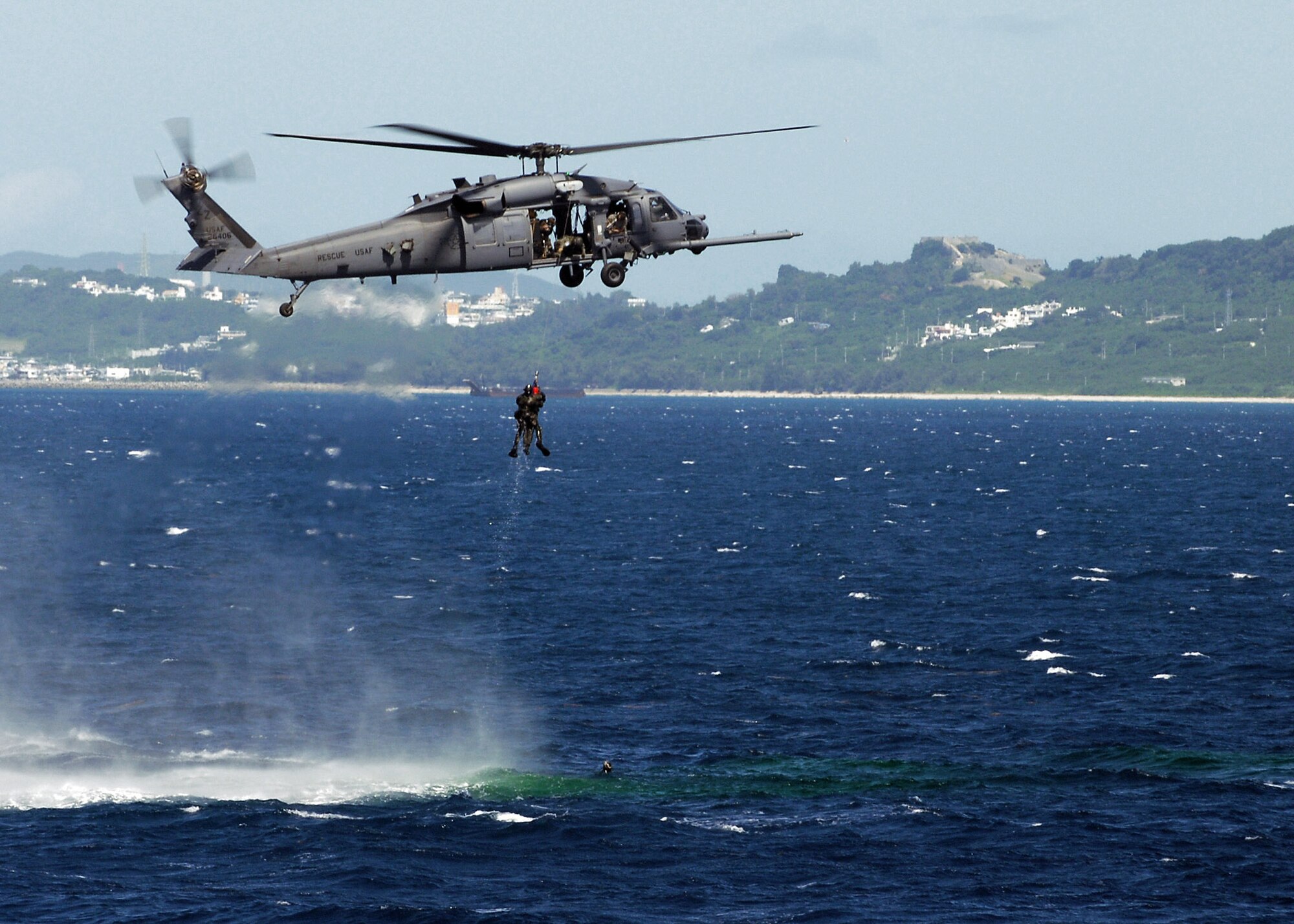 An aircrew on board an HH-60G Pave Hawk hover over one of two downed pilots during a crisis management exercise Oct. 8 off the coast of Okinawa, Japan. Members of the 18th Wing from Kadena Air Base, Japan, and the Japanese coast guard rehearsed response procedures for a simulated over the water aircraft accident. The aircrew are assigned to the 33rd Rescue Squadron. (U.S. Air Force photo/Airman 1st Class Amanda Grabiec) 
