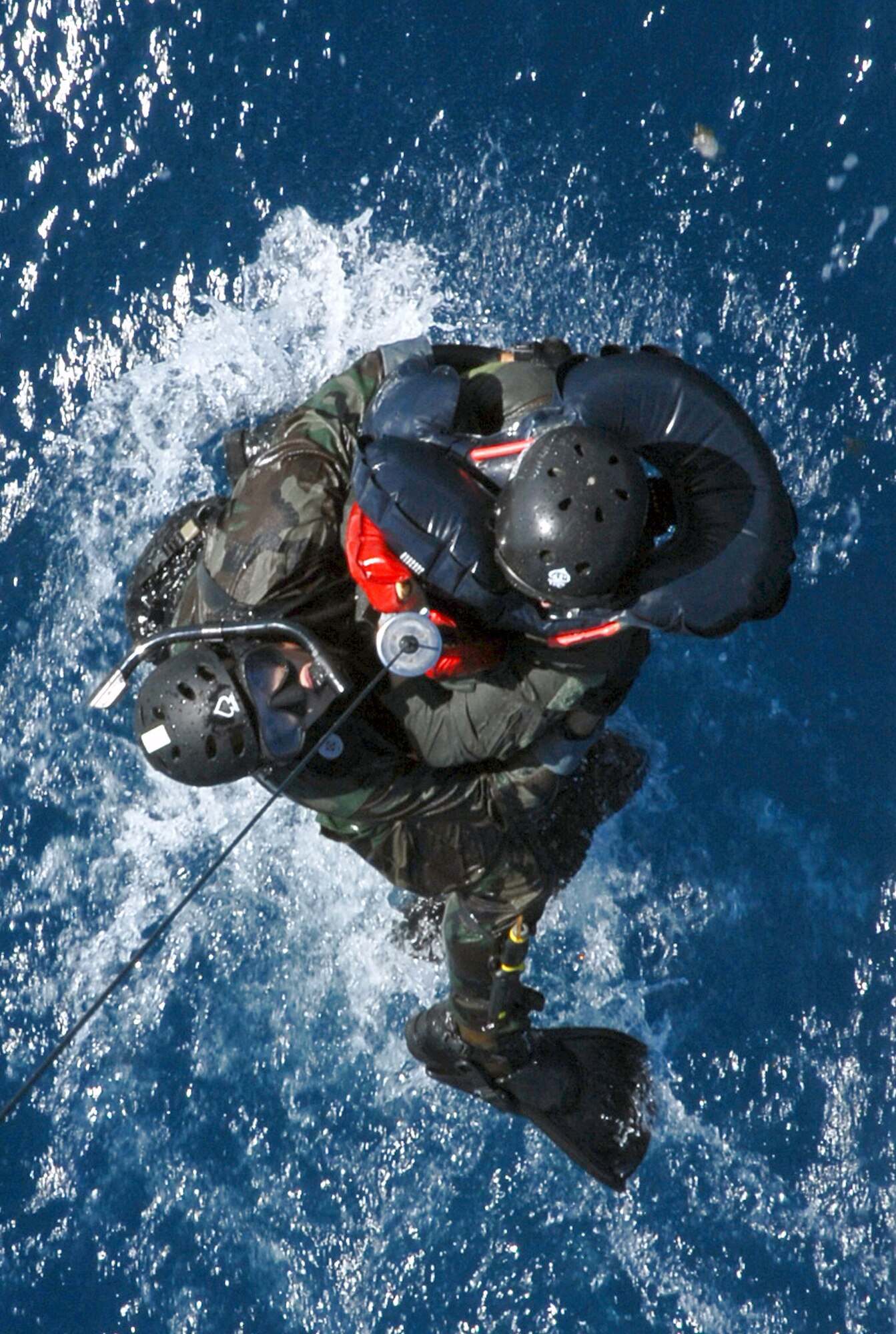 Senior Airman Oliver Smith and a downed F-15 Eagle pilot are hoisted out of the water into a HH-60G Pave Hawk during a crisis management exercise Oct. 8 off the coast of Okinawa, Japan. Members of the 18th Wing from Kadena Air Base, Japan, and the Japanese coast guard rehearsed response procedures for a simulated over the water aircraft accident. Airman Smith is a pararescue Airman assigned to the 31st Rescue Squadron. (U.S. Air Force photo/Staff Sgt. Chrissy Best) 
