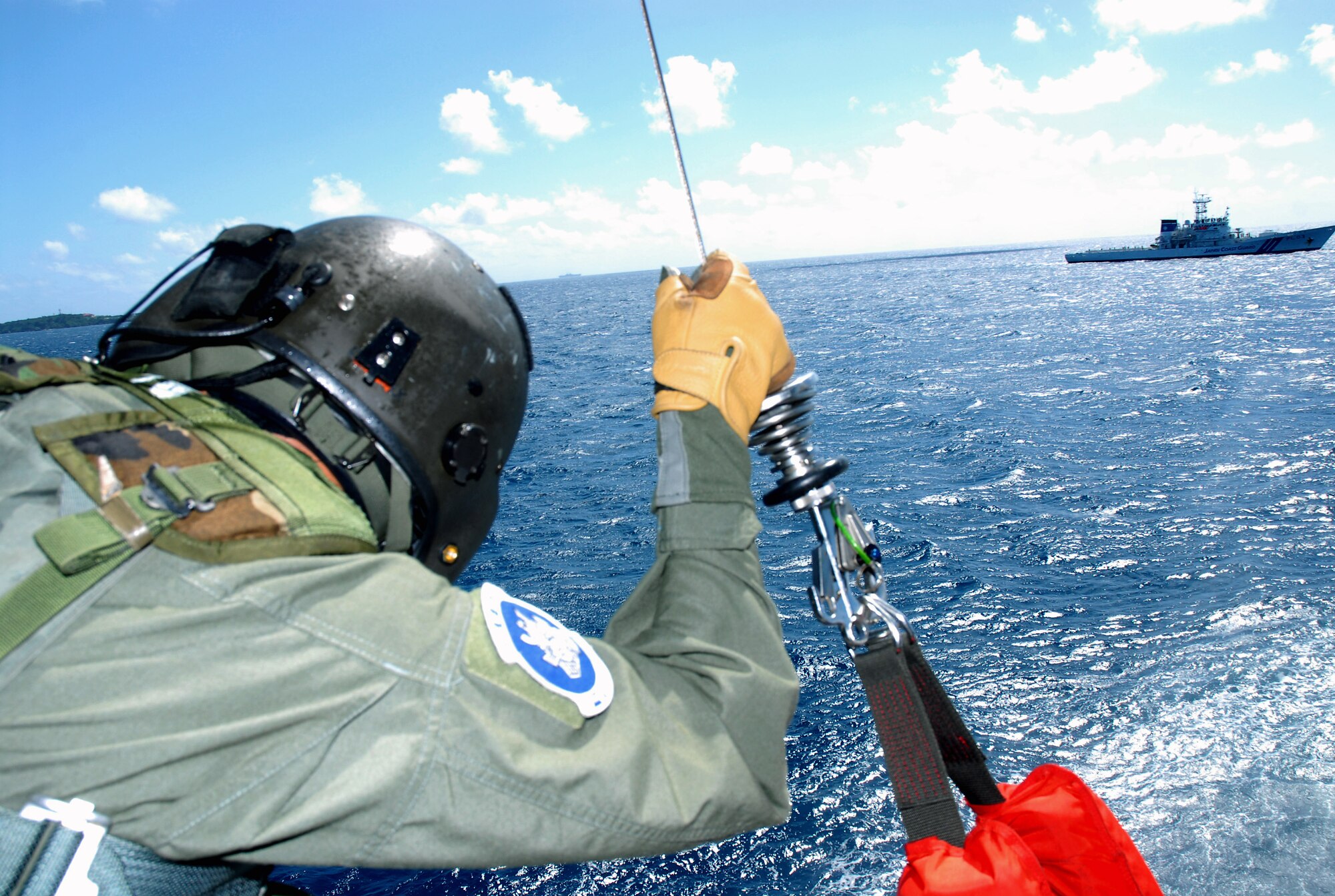 Master Sgt. Ernest Garcia waits for a signal from the pararescue Airman in the water to bring the downed pilot onboard an HH-60G Pave Hawk during a crisis management exercise Oct. 8 off the coast of Okinawa, Japan. Members of the 18th Wing from Kadena Air Base, Japan, and the Japanese coast guard rehearsed response procedures for a simulated over the water aircraft accident. Sergeant Garcia is a flight engineer assigned to the 33rd Rescue Squadron. (U.S. Air Force photo/Staff Sgt. Chrissy Best) 
