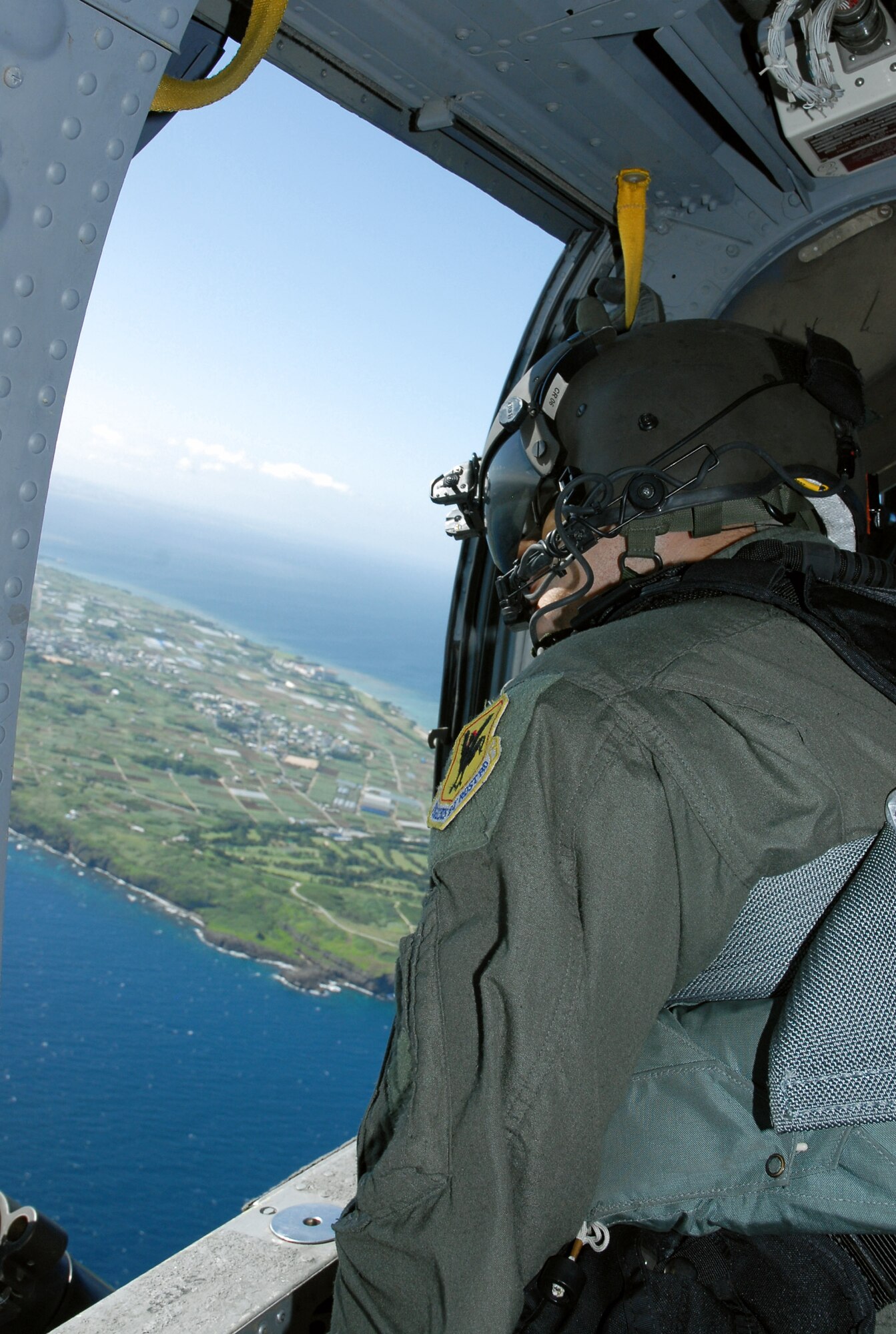 Staff Sgt. Justin Schramm scans the sky and water below from an HH-60G Pave Hawk prior to a crisis management exercise Oct. 8 off the coast of Okinawa, Japan. Members of the 18th Wing from Kadena Air Base, Japan, and the Japanese coast guard rehearsed response procedures for a simulated over the water aircraft accident. Sergeant Schramm is an aerial gunner assigned to the 33rd Rescue Squadron. (U.S. Air Force photo/Staff Sgt. Chrissy Best) 
