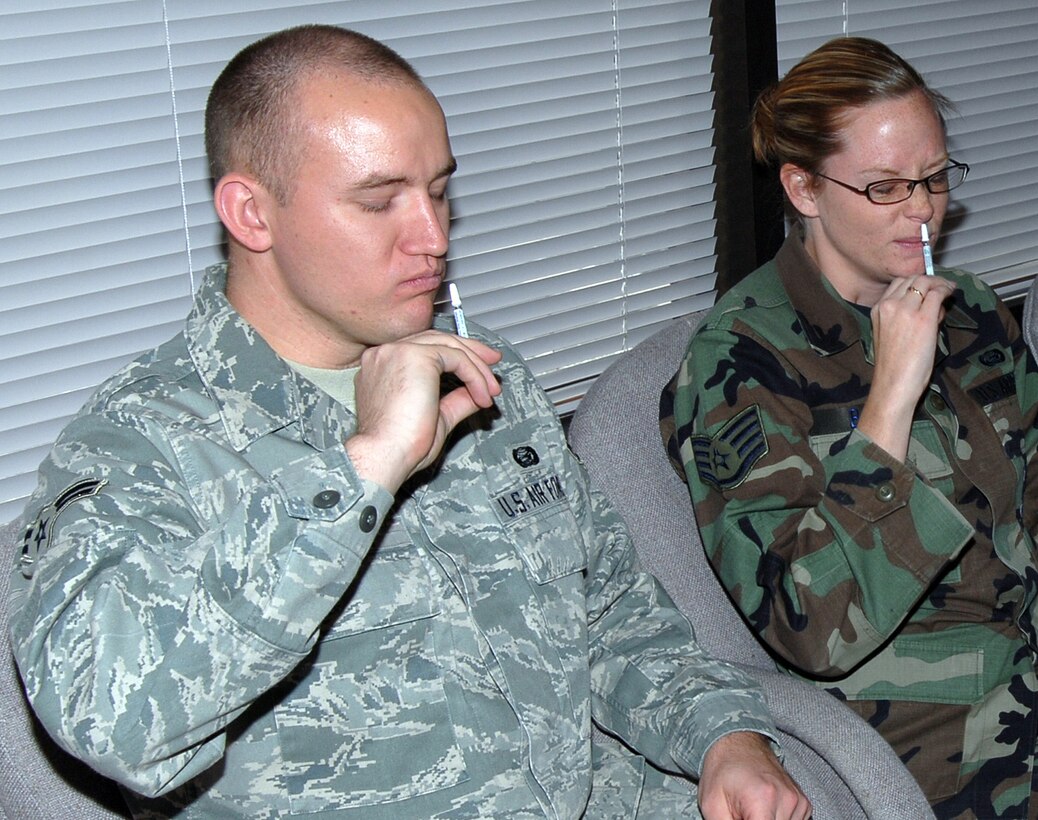 Airman 1st Class Jeremiah Golding and Staff Sgt. Valerie Baker, DPS, vaccinate themselves with the flu mist during military flu vaccinations at ARPC on Oct. 8. Flu mist is administered nasally. The flu shot is being offered to civilian employees beginning Oct. 14. Airmen will have another chance to receive the vaccine sometime later this month. (U.S. Air Force photo/Dwayne Beuthel) 