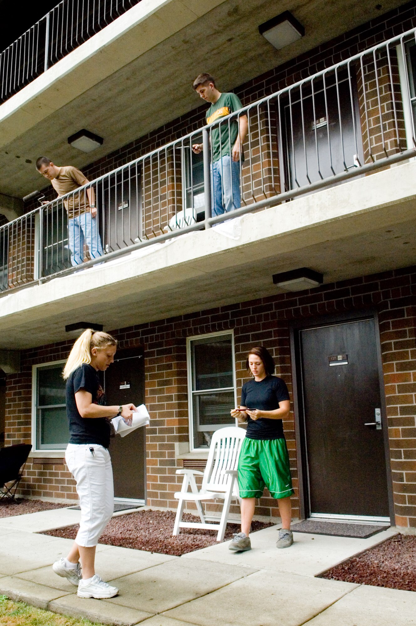 Senior Airman Melissa Butterfield, 10th Airlift Squadron and Airman 1st Class Kelsey Gainer, 8th Airlift Squadron, replace nameplates as Airmen paint the railing above. More than 30 Airmen, first sergeants, chiefs and squadron commanders worked Oct. 2 to clean and paint Dormitory 574 improving the dorm’s condition and quality of life for residents. Project planners also sought to boost the pride of Airmen who live there. Future improvement plans may include flat screen TVs, hardwood flooring and game tables in the day room.