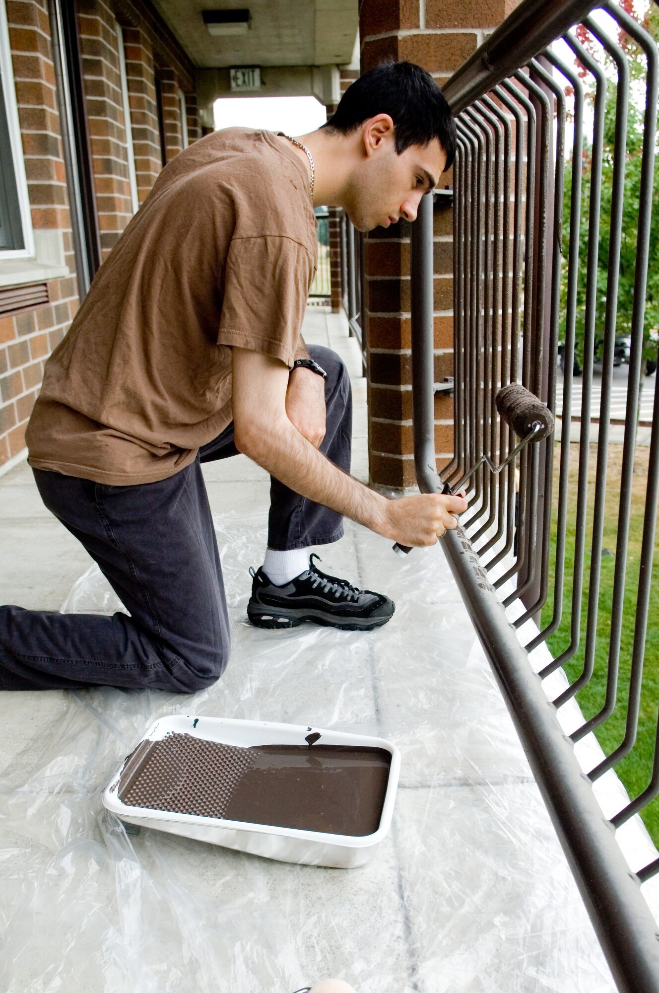 Senior Airman Derek Lopez, 8th AS, paints the railing on the second floor balcony of Dormitory 574.