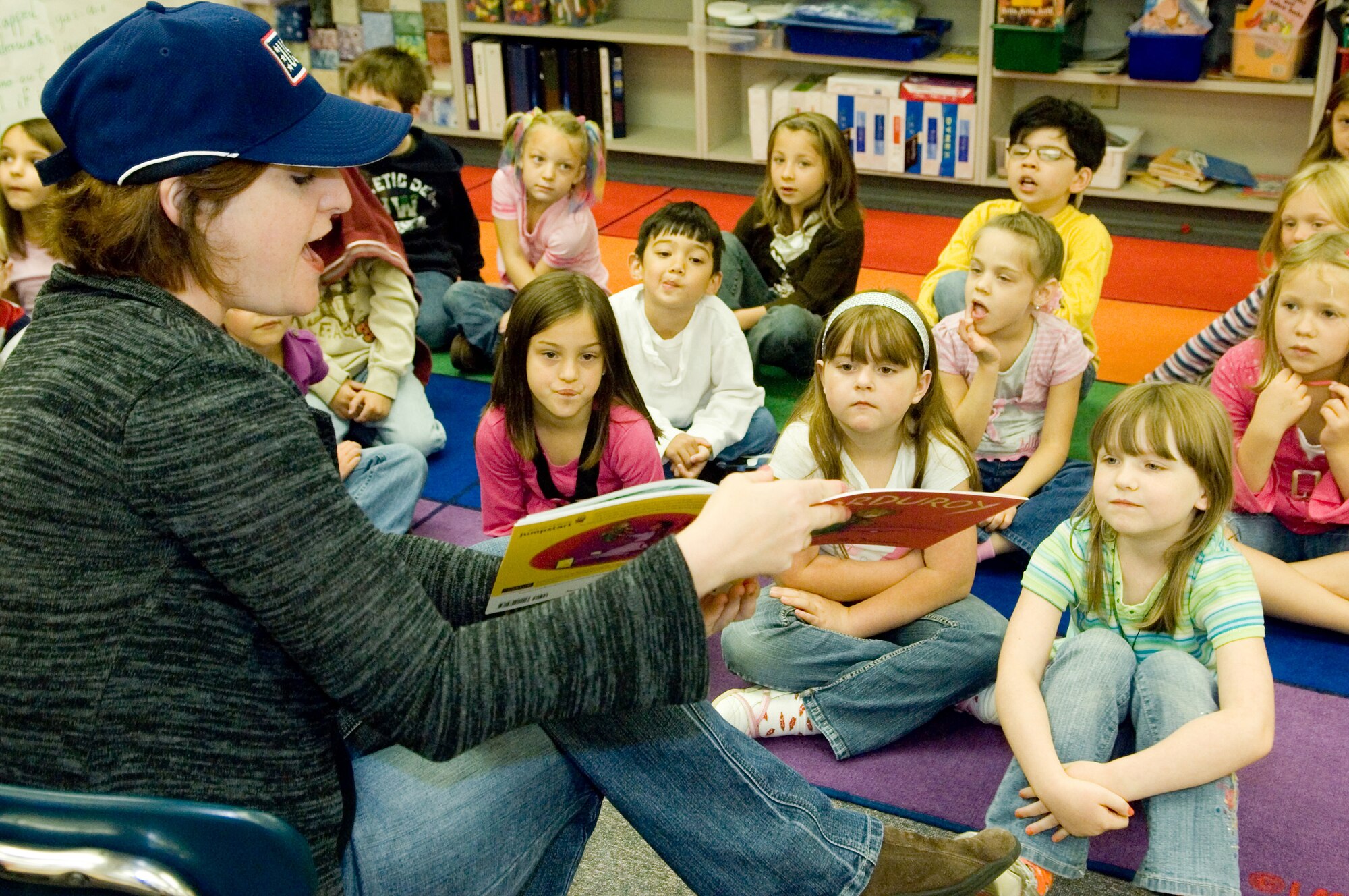 Tracye Kakely, McChord United Services Organization center manager, reads “Corduroy” by Dan Freeman to a group of first graders Thursday at Carter Lake Elementary as part of the Read for Record Jumpstart campaign. More than 162 children in the kindergarten and first grade participated in the event and also received the book to take home. The national initiative raises awareness of the importance of early childhood education and encourages hundreds of thousands of children and adults to read the same book on the same day.