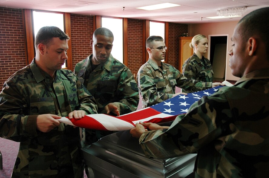 Tech Sgt. Charles Forrest, U.S. Air Force Honor Guard’s noncommissioned officer in charge of formal training, right, instructs a flag-folding team during a visit to Peterson Air Force Base, Colo. (Photo courtesy of U.S. Air Force Honor Guard)