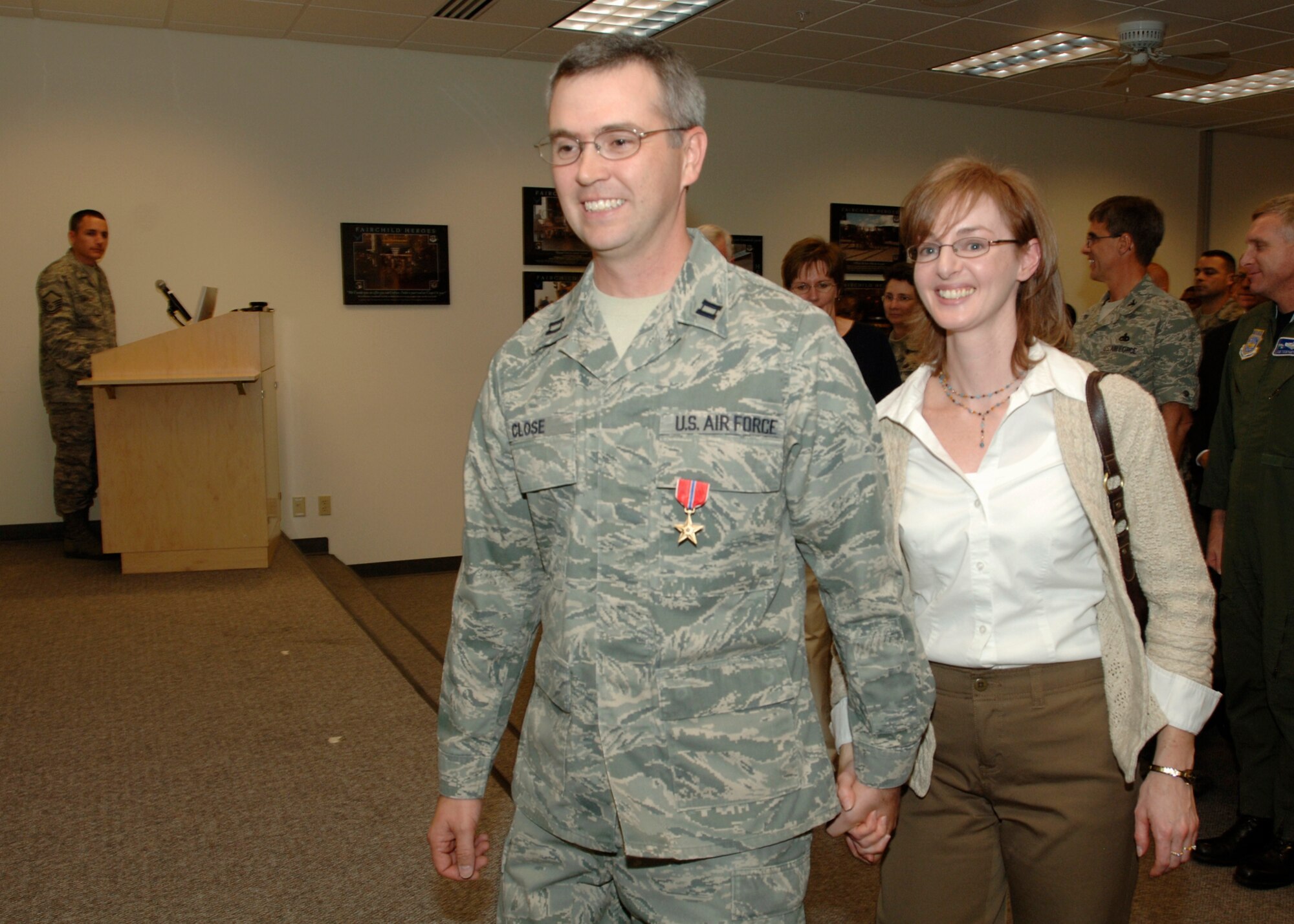 FAIRCHILD AIR FORCE BASE, Wash. – Bronze Star recipient Capt. Carl Close and his wife, Kara, walk off stage after a medal ceremony Monday afternoon recognizing the captain's efforts in Kandahar Afghanistan. Kara stayed behind during the year he was deployed to Afghanistan, a hardship many military families endure during today’s high operations tempo. “A year is a long time,” said Captain Close during his ceremony speech. “I thank my wife for being here.” The captain’s father, visiting from North Carolina, also attended the ceremony. (U.S. Air Force photo / Airman 1st Class Melissa Barnett)