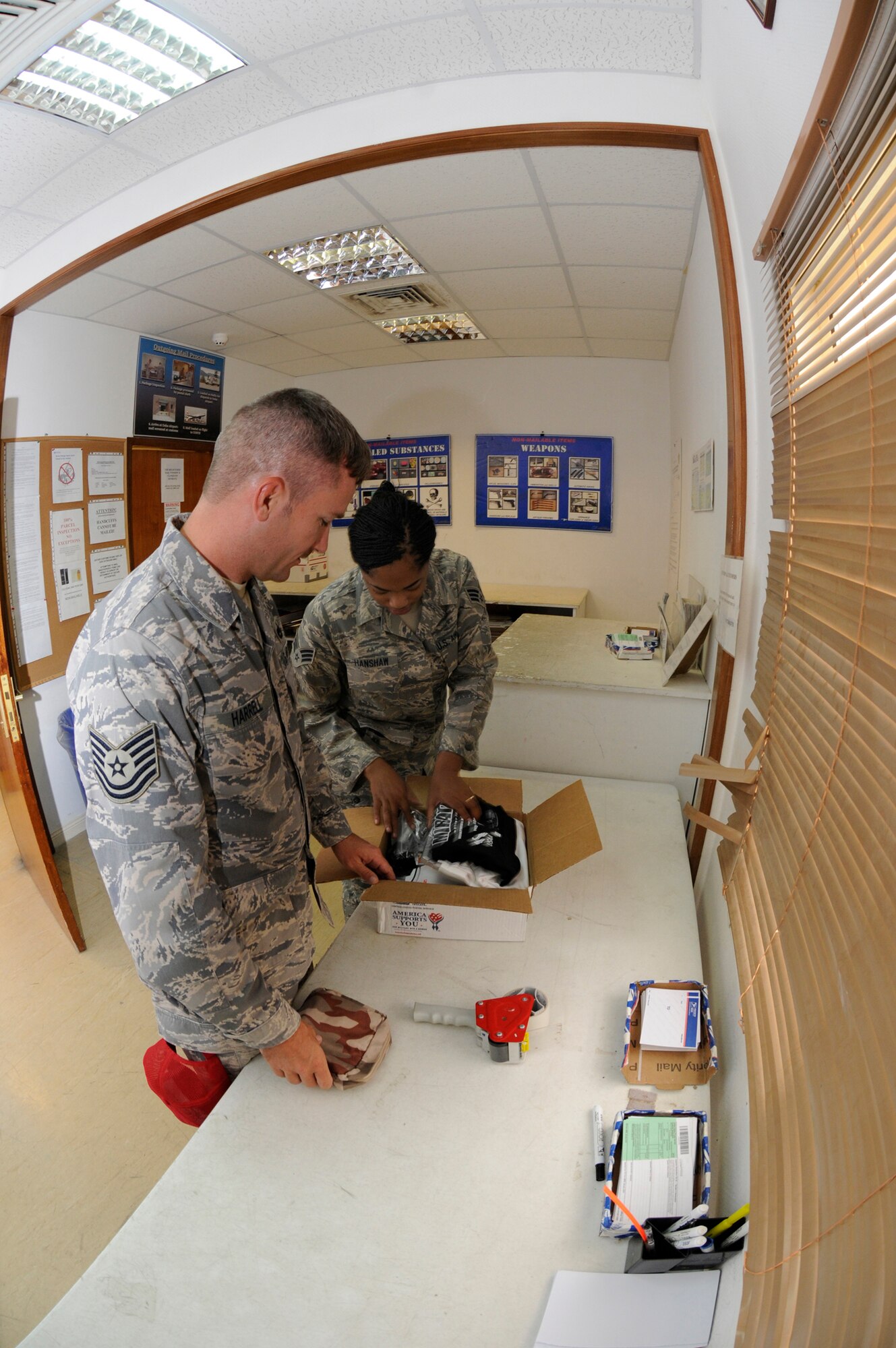 Senior Airman Ashley Hanshaw, 379th Expeditionary Communication Squadron, performs a postal inspection of a package that Tech. Sgt. Mark Harrell, 1st Expeditionary Rapid Engineer Deployable Heavy Operational Repair Squadrons Engineer (RED HORSE) Group is mailing off Sept. 29, 2008.  Every package processed through the mail center must be inspected before shipment from this undisclosed location in Southwest Asia.  Airman Hanshaw is a native from the Bronx, N.Y., and deployed from Dobbins Air Force Base, Ga., and Sergeant Harrell hails from Wilmington, N.C., and deployed from Hurlburt Field Fla., both are here in support of Operations Iraqi and Enduring Freedom and Joint Task Force-Horn of Africa.  (U.S. Air Force photo by Tech. Sgt. Michael Boquette/Released)