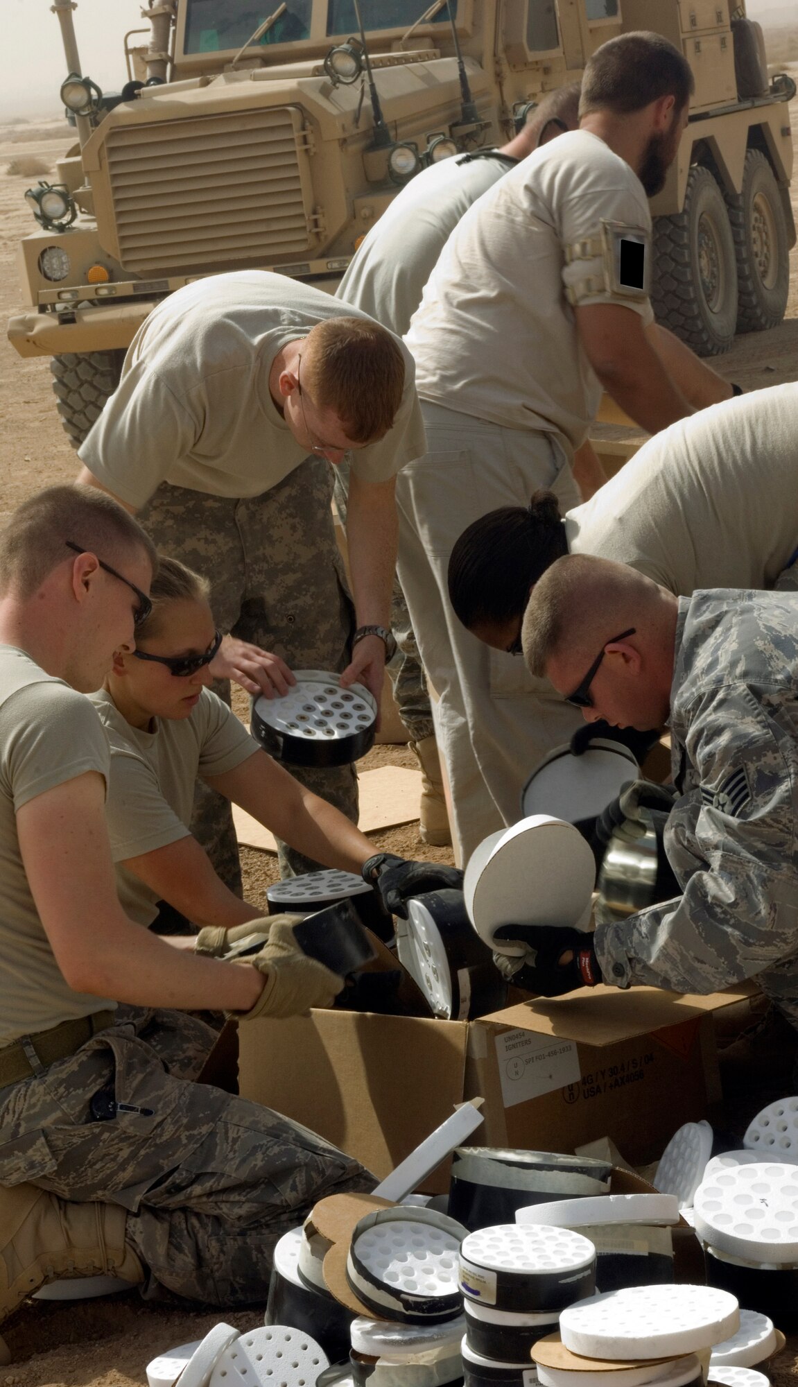 Airmen with the 332nd Expeditionary Civil Engineer Squadron Explosive Ordinance Disposal teams and the 332nd Expeditionary Aircraft Maintenance Squadron, as well as observers and contractors, help unpack expired ammunition and explosives. The destruction of these items by controlled detonation will save the government thousands of dollars that otherwise would be spent shipping the munitions to the United States. (U.S. Air Force photo/Tech. Sgt. Erik Gudmundson)