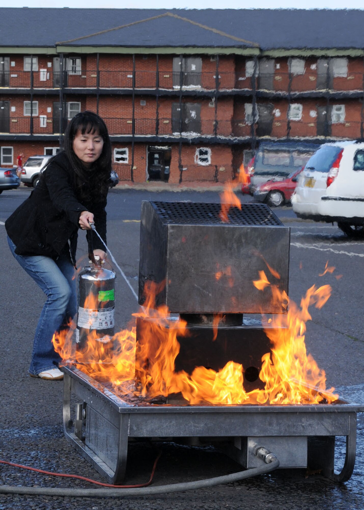 Eri Harp, tries her best to extinguish a controlled fire during a fire extinguisher training demonstration in the parking lot of the Bob Hope Community Center Oct. 8, 2008, at RAF Mildenhall, England. The hands-on extinguisher training gave servicemembers and their families experience on how to safely put out a fire. The training was all part of “Fire Prevention Week” which began Oct. 5 through 11 giving service members and their families information on fire safety. (U.S. Air Force photo by Staff Sgt. Jerry Fleshman)