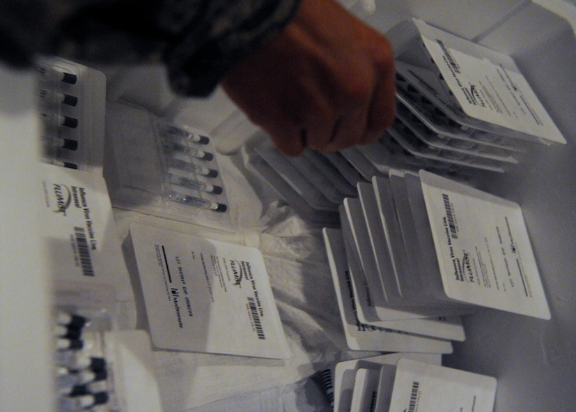 MOODY AIR FORCE BASE, Ga. -- Airman 1st Class Joshua Peterson, 23rd Medical Group, grabs packets of intranasal flu mist, a live influenza strand, from a storage container here Oct. 7. The 23rd Medical Group administered the mandatory mist at the base theater for all active duty personnel before the upcoming "flu season." (U.S. Air Force photo by Senior Airman Brittany Barker)