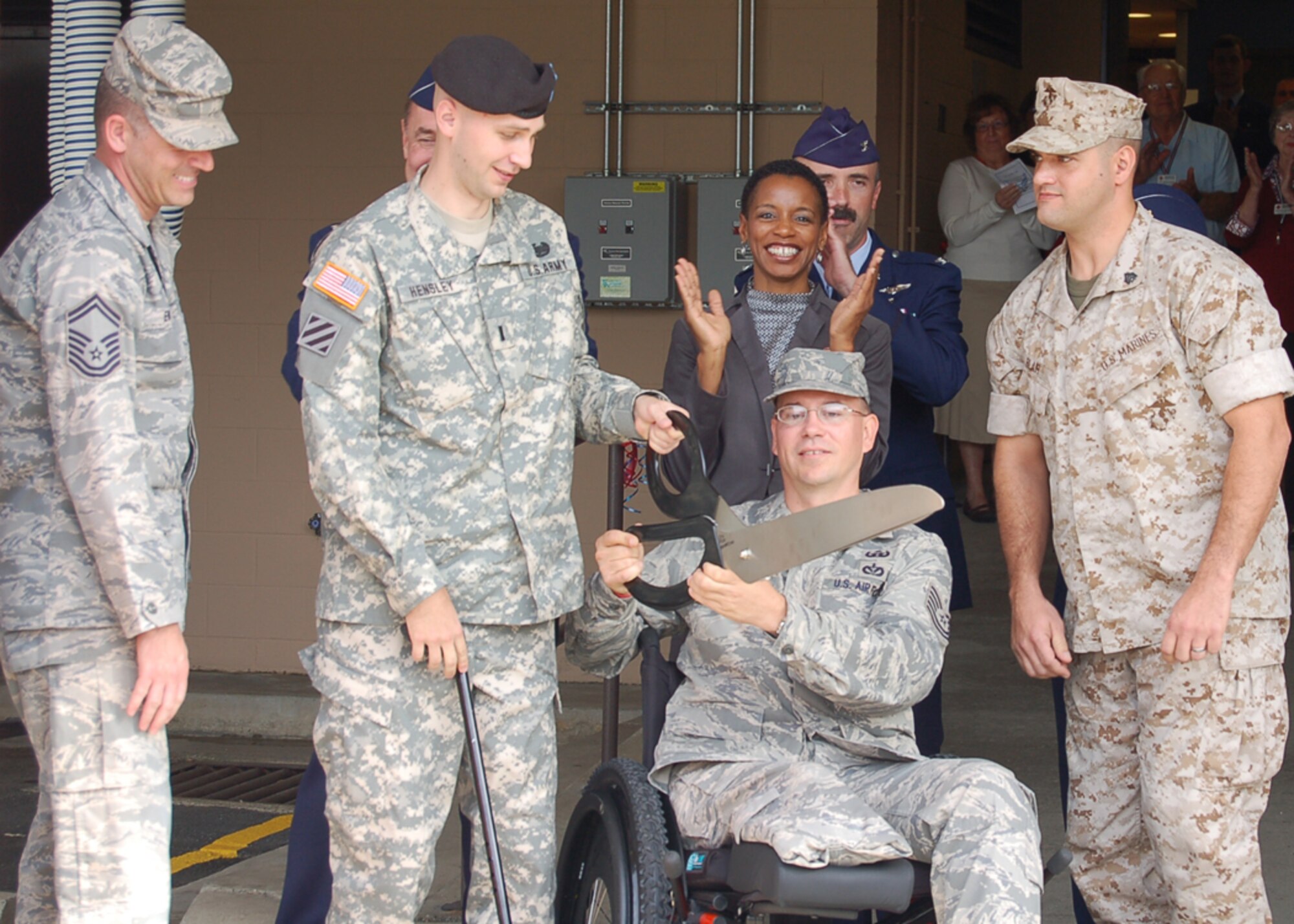 Wounded warriors Senior Master Sgt. William Ewing, Army 1st Lt. Jeff Hensley, Tech. Sgt. Christopher Frost, and Marine Sgt. Kenneth Blair cut the ribbon to open the renovated 779th Aeromedical Staging Facility on Andrews Air Force Base, Md., Oct. 9.  Maj. Gen. Gar Graham, 79th Medical Wing commander; Congresswoman Donna Edwards, Maryland’s 4th Congressional District; and Col. Robert Miller, 779th Medical Group commander applaud behind them.  The $4.9 million-dollar renovation project ensures service members returning from overseas receive the “heroes welcome they deserve,” Colonel Miller said.  (U.S. Air Force photo by Senior Master Sgt. Michael Land)