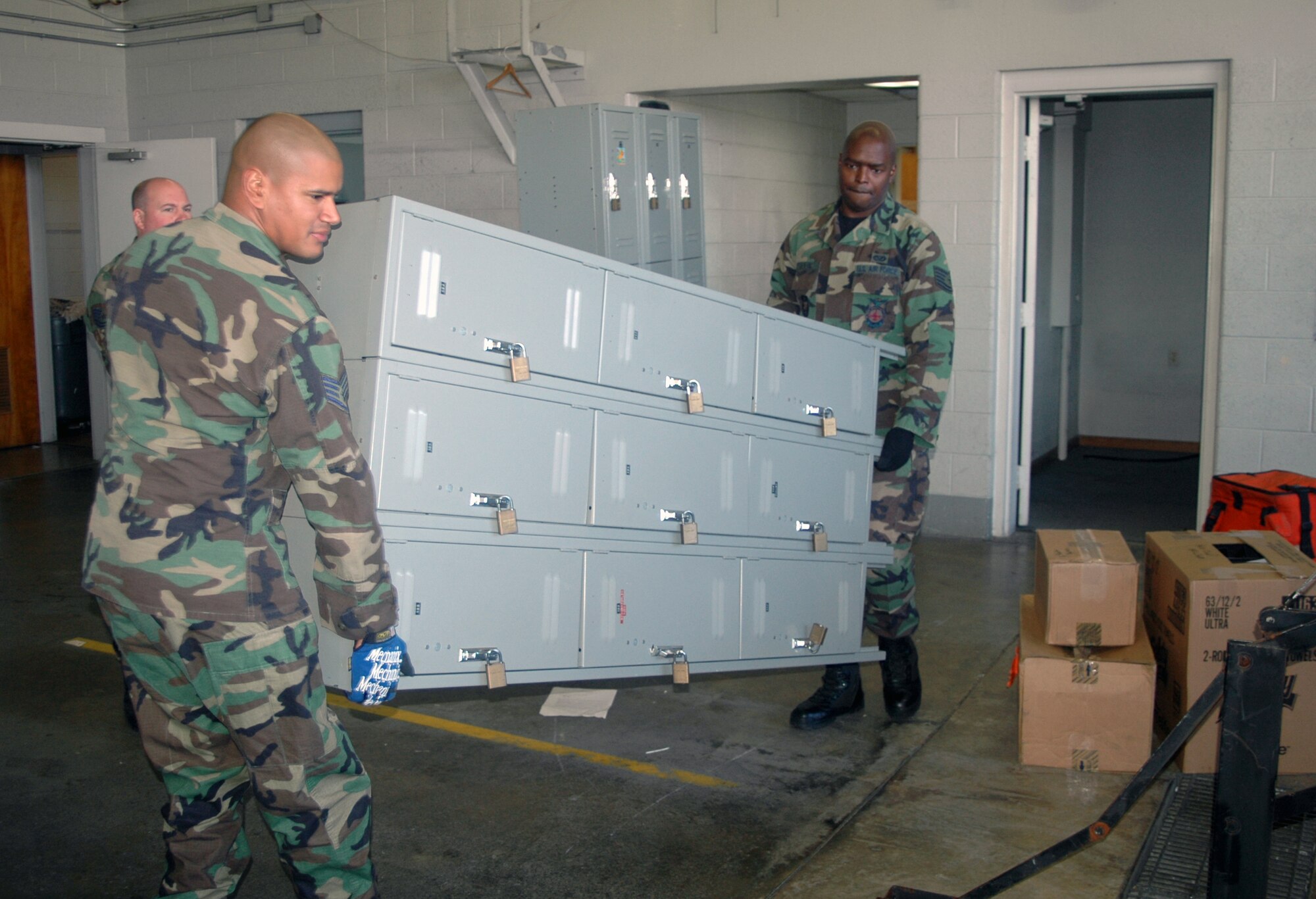 Staff Sgt. Manuel Ortez (left) and Tech. Sgt. Stephen Taylor, both 512th Civil Engineer Squadron firefighters, move office supplies and equipment out of Fire Station 2, Building 1320, Oct. 9. The squadron is moving to Fire Station 1 while their building undergoes a $1.4 million renovation, which should take about a year to complete. (U.S. Air Force photo/Capt. Marnee A.C. Losurdo) 
