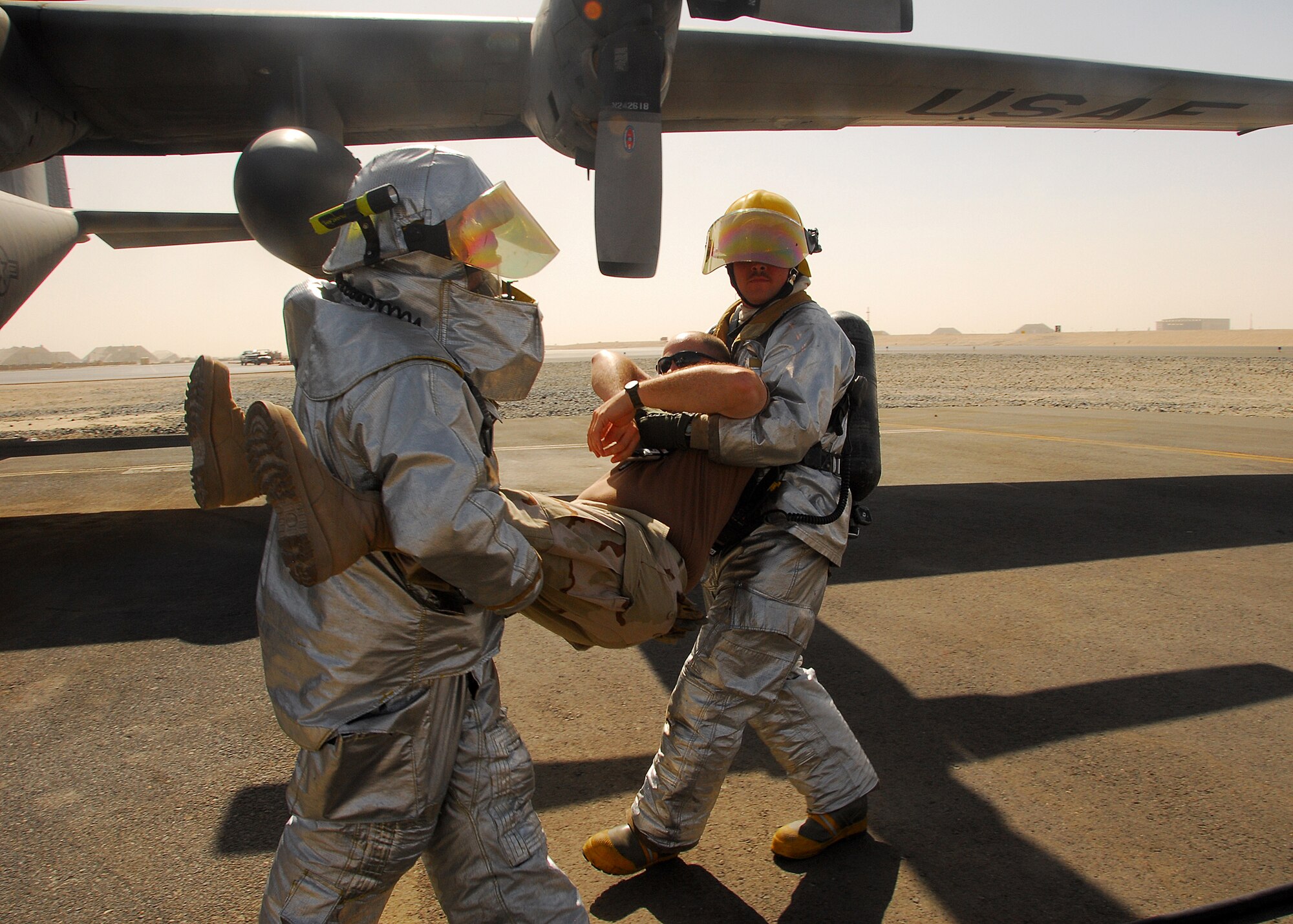 SOUTHWEST ASIA  -- Firefighters with the 386th Expeditionary Civil Engineer Squadron fire department remove a simulated fire victim from a C-130 Hercules in search of a simulated fire victim during an aircraft egress training scenario on Oct. 6 at an air base in Southwest Asia. The 386th ECES fire department conducts day and night training on various airframes and structures up to four times a month. (U.S. Air Force photo/Staff Sgt. Vincent Borden)
