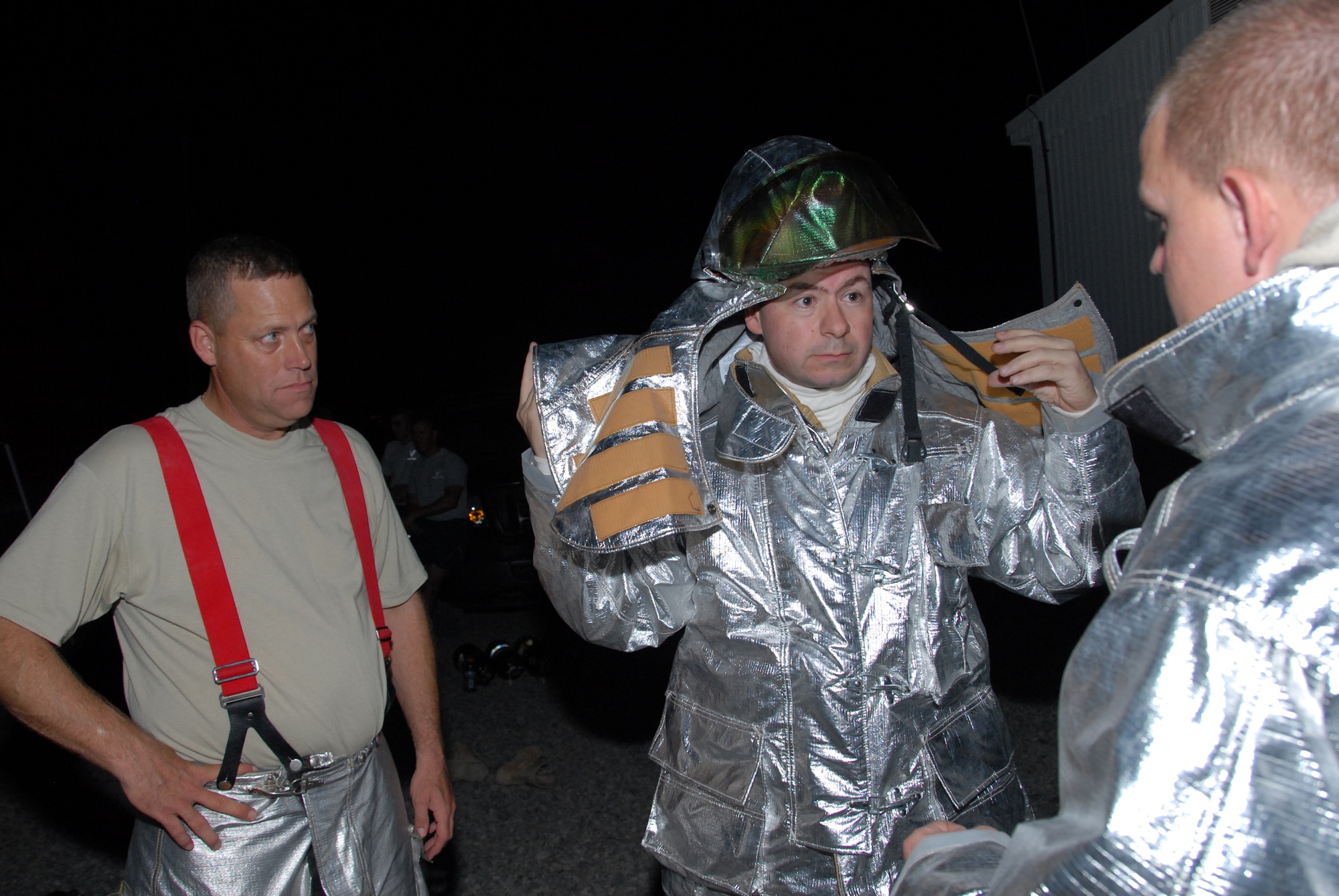 SOUTHWEST ASIA--Senior Airman Brice Martin briefs Col. Paul Murphy, 380th Air Expeditionary Wing vice commander, while Chief Master Sgt. Martin Smith, 380th AEW command chief  looks on prior to entering the smokehouse trainer here. The smokehouse trainer was opened to allow fellow Airmen from the base to don firefighter equipment and work in zero-visibility conditions. Airman Martin, deployed from McGuire Air Force Base, N.J. is a driver/operator and crew chief with the 380th Expeditionary Civil Engineer Squadron's Fire Protection Flight. His hometown is Savannah, Mo.(released/photo by 1st Lt. Michael Frye)