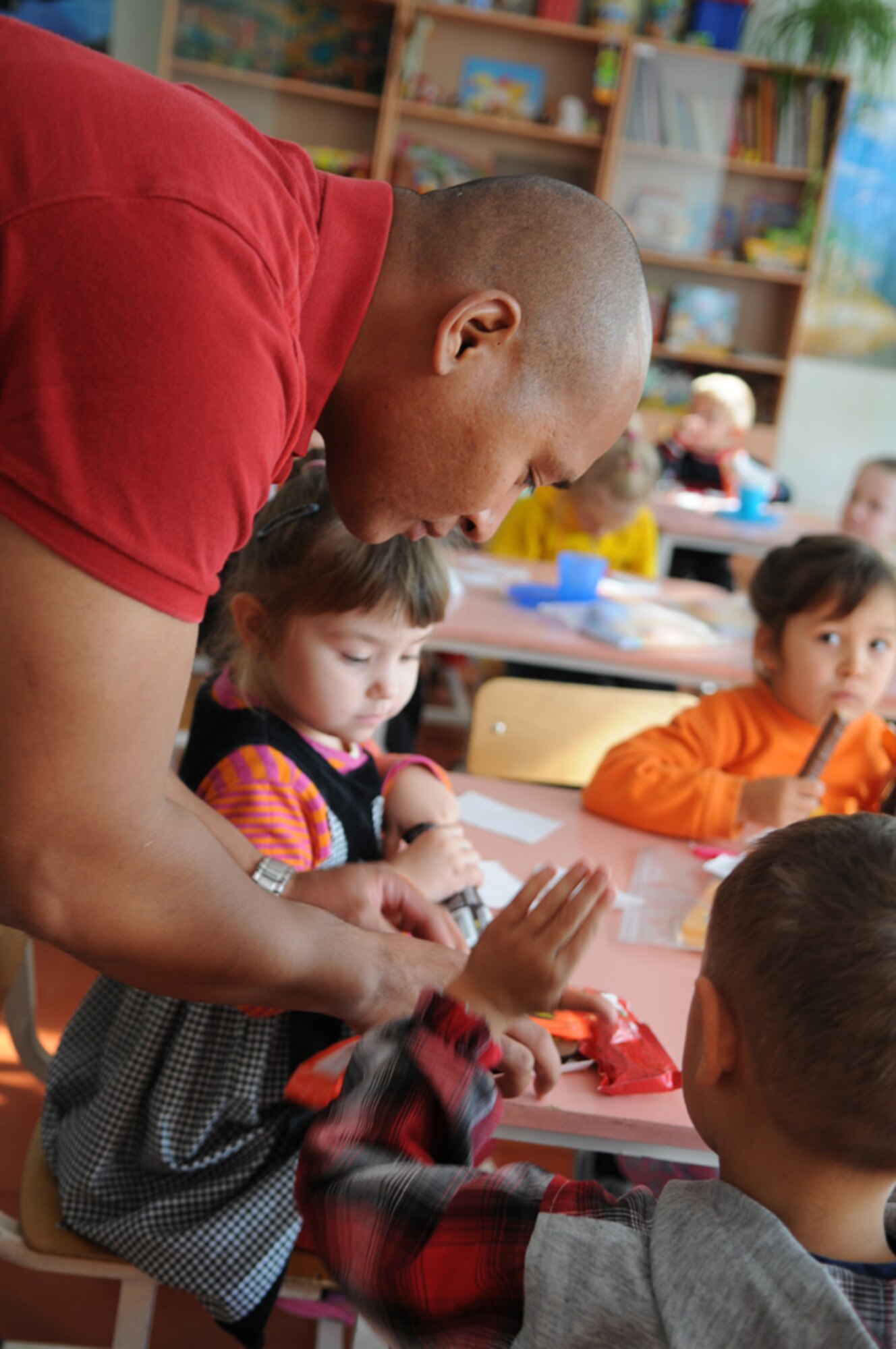 Tech. Sgt. Michael Jackson, 376th Expeditionary Mission Support Group, hands out candy bars to the children at Vasilievika Elementary School, Oct. 7. Together the 376th Air Expeditionary Wing Staff and Operations Group have supported the school since 2004, pulling together donations, pooling skills such as painting and carpentry and just spending time with the kids. (Air Force photo / Senior Airman Ruth Holcomb)