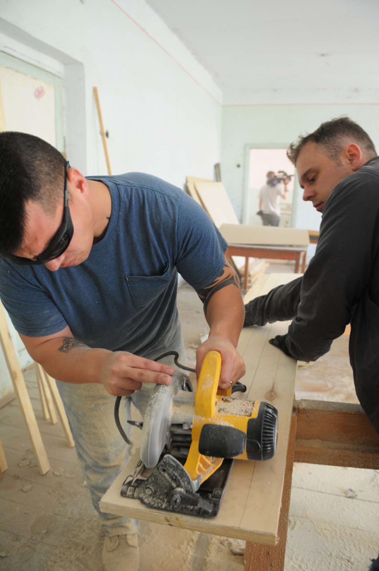 Staff Sgt. Brandon Arenibar, 376th Expeditionary Operations Group, (left) and Tech. Sgt. Michael Voss, 376th Air Expeditionary Wing, saw wood to create insulated frames for the windows at the Vasilievika Elementary School, Oct. 7. Together the 376th Air Expeditionary Wing Staff and Operations Group have supported the school since 2004, pulling together donations, pooling skills such as painting and carpentry and just spending time with the kids. (Air Force photo / Senior Airman Ruth Holcomb)