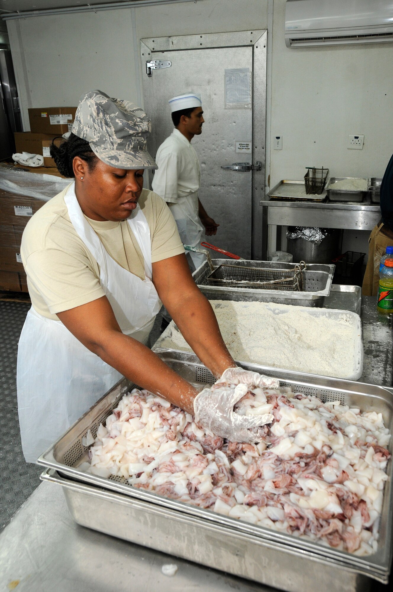 Staff Sgt. Jocelyn Foster, 379th Expeditionary Force Support Squadron, applies breading to calamari in preparation for frying October 9, 2008. The breading and frying are completed with technical help from employees of the Outback Steakhouse here at an undisclosed air base in Southwest Asia.  The Outback brought in food and expertise in a show of support for our troops supporting Operations Iraqi and Enduring Freedom and Joint Task Force-Horn of Africa.  (U.S. Air Force photo by Tech. Sgt. Michael Boquette/Released)