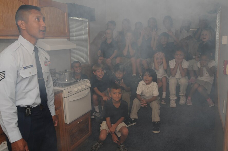 ANDERSEN AIR FORCE BASE, Guam - Staff Sgt. Roderick Marquez, 36th Civil Engineer Squadron firefighter, activates pepper fog to simulate smoke during Fire Prevention Week at Andersen Elementary School hereOct. 9. Pepper fog is a non-harmful substance used to demonstrate proper exit strategies in case of a fire. (U.S. Air Force photo by Senior Airman Sonya Croston)