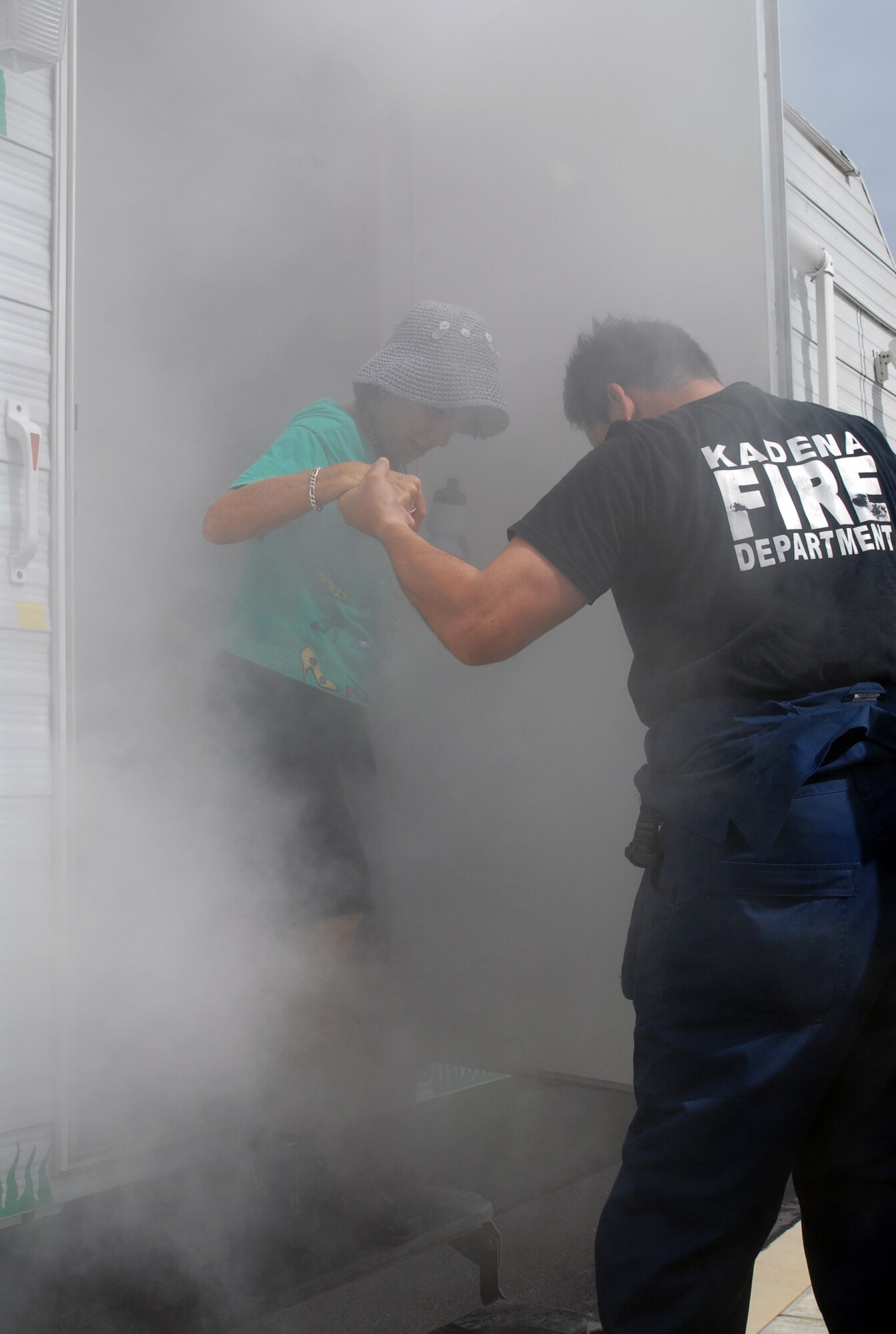 Ms. Margarite Levitt, a physical education teacher at Ryukyu Middle School, emerges from the Kadena Fire Department's "Smoke House" after going in alongside her students Oct. 9.  The trailer simulated a two-story building filled with smoke and showed students the difficulty of finding their way around in a low vision environment. (U.S. Air Force photo/Staff Sgt. Christopher Marasky)
