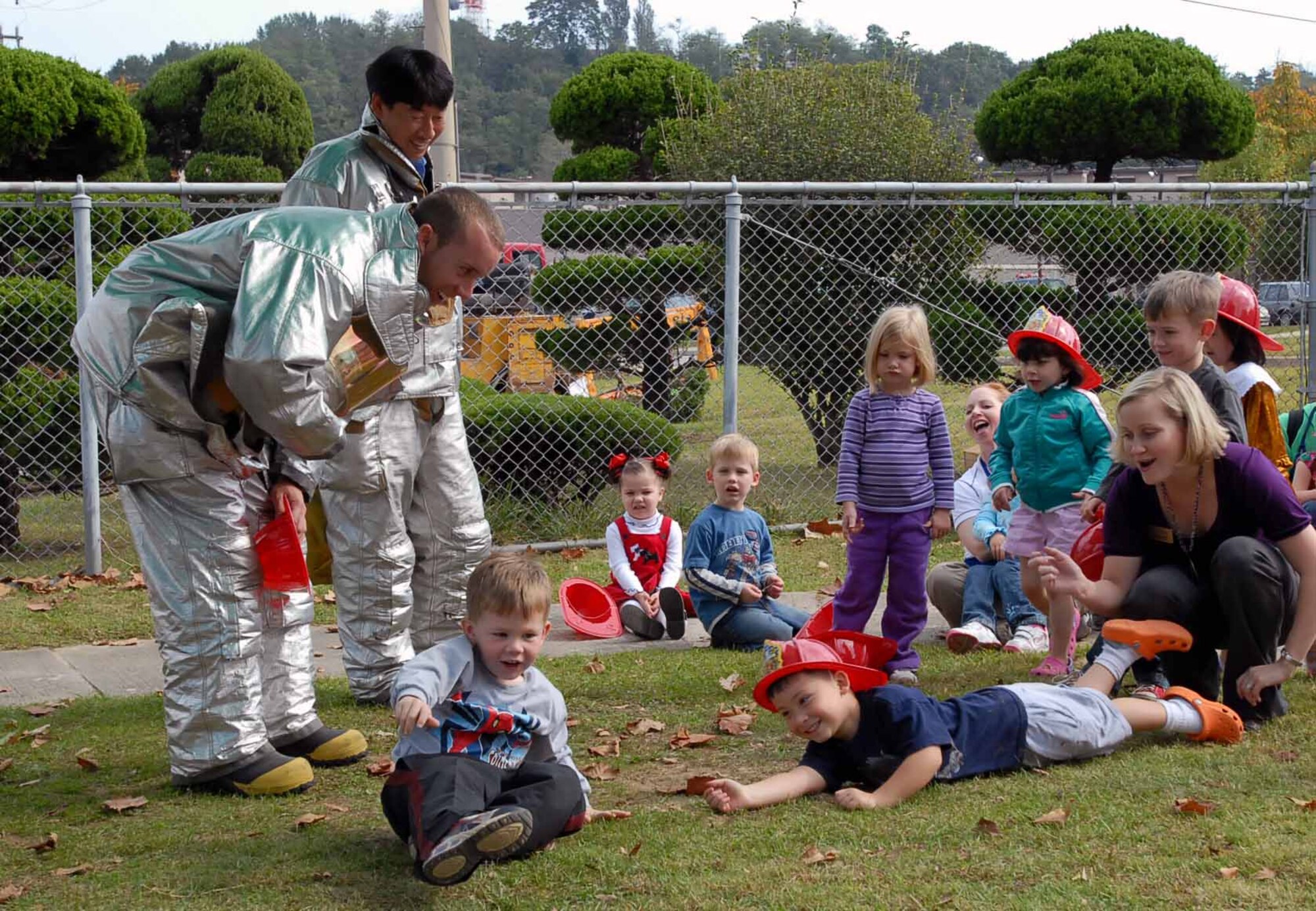 OSAN AIR BASE, Republic of Korea -- Staff Sgt. Walter Schutler, Osan firefighter, teaches children at the Osan Child Development Center the proper way to stop, drop, and roll.  During Fire Prevention Week, Oct. 6 to 10, firefighters held numerous events designed to teach all of Team Osan how to prevent fires. (U.S. Air Force/Master Sgt. Marlin Zimmerman)