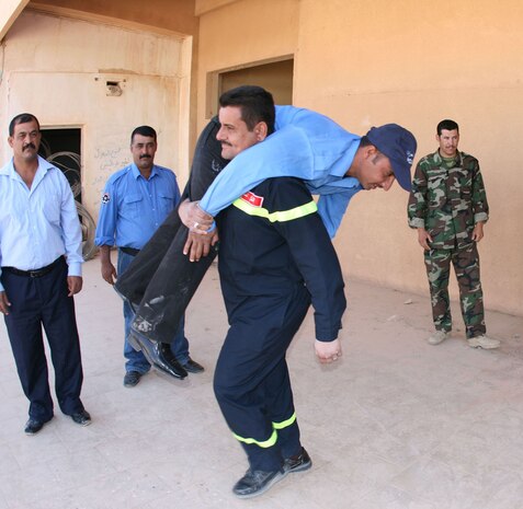 An Iraqi fireman practices utilizing the fireman's carry technique he'd just learned during a first aid class taught by Coaltion forces from the Trebil Port of Entry Transition Team Oct. 11.  Trebil is located in al-Anbar province on Iraq's western border with Jordan, and is one of the main avenues through which commerce passes into and out of Iraq.