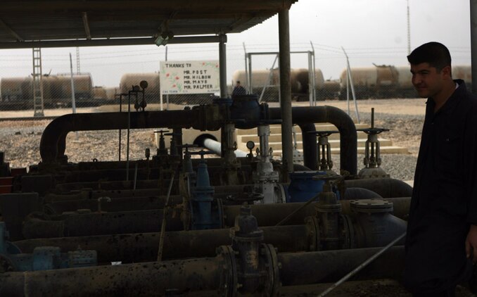 An Iraq oil worker monitors crude oil as it passes from the incoming trains in Haqlaniyah, Iraq, Oct. 12, to reservoir tanks.  The oil will then be refined at the Haqlaniyah refinery and distributed all around al-Anbar province. Marines and sailors with Civil Affairs Team 6, Detachment 1, 2nd Battalion 11th Marine Regiment, Regimental Combat Team 5 have been working for approximately four months to get the train station running and receiving trains.