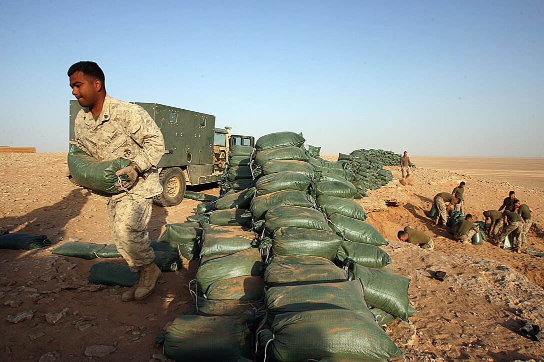 SHADOW RANGE, Iraq – Sergeant Santiago Cervantes, instructor, Advanced Infantry Training Center, Multi National Forces-West, helps load sandbags for range lines here Oct. 12. Santiago, 25, Merced, Calif., is one of many instructors AITC brought to teach Marines combined-arms courses. Shadow Range is a combined-arms range capable of supporting company-level training operations. Shadow is only initially capable right now, but plans are for the range to be fully operational capable this upcoming December or January. The courses offered here include a 14-day Tactical Small Unit Leaders Course, a seven-day Female Search Team certification course, a five-day Combined Arms Training Program for team to platoon sized training and a ten-day Combined Arms Training Program for team to company sized training. The range also supports mechanized assault training, aviation, artillery and mortar training.  (Marine photo by Cpl. GP Ingersoll)