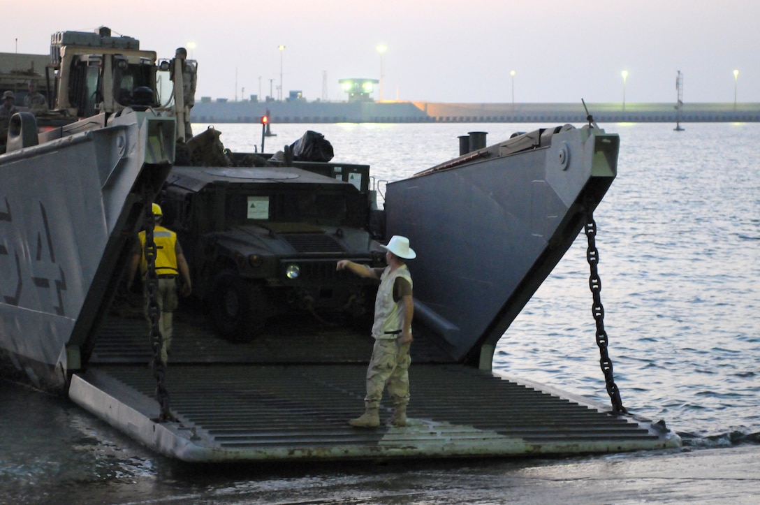 from the Iwo Jima Strike Group prepare to offload tactical equipment and Marines from the 26th Marine Expeditionary Unit.