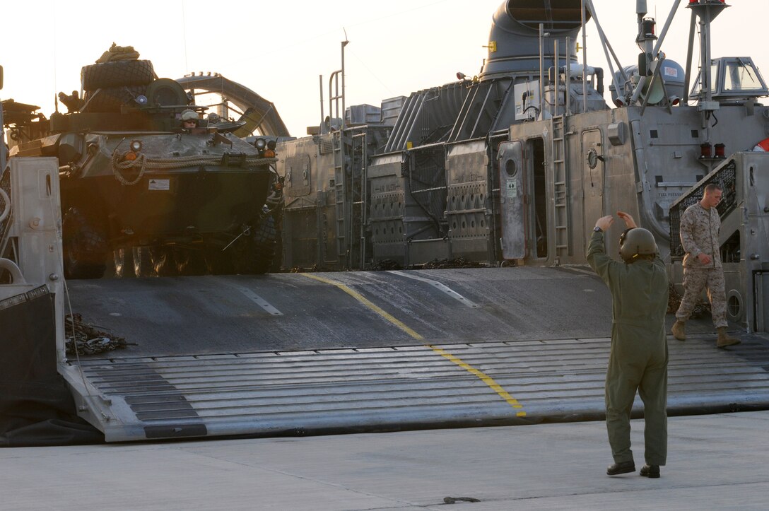 The Landing Craft Air Cushioned amphibious vehicle's loadmaster directs vehicles off the LCAC. The LCAC handles a normal load of 60 tons and can handle an overload of up to 75 tons.