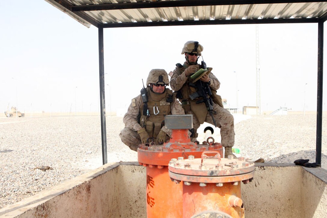 Navy Lt. Eric I. Palmer (left), officer-in-charge, and Staff Sgt.Graham H. Webb (right), 26, team chief, both with CA Team 6, Detachment 1, 2nd Battalion, 11th Marine Regiment, Regimental Combat Team 5, monitor the levels of crude oil that is being pumped out of the incoming train cars in Haqlaniyah, Iraq, Oct. 12. Marines and sailors with CA Team 6 make sure the trains are arriving at the train station in Haqlaniyah without encountering any obstructions and running at full capacity.