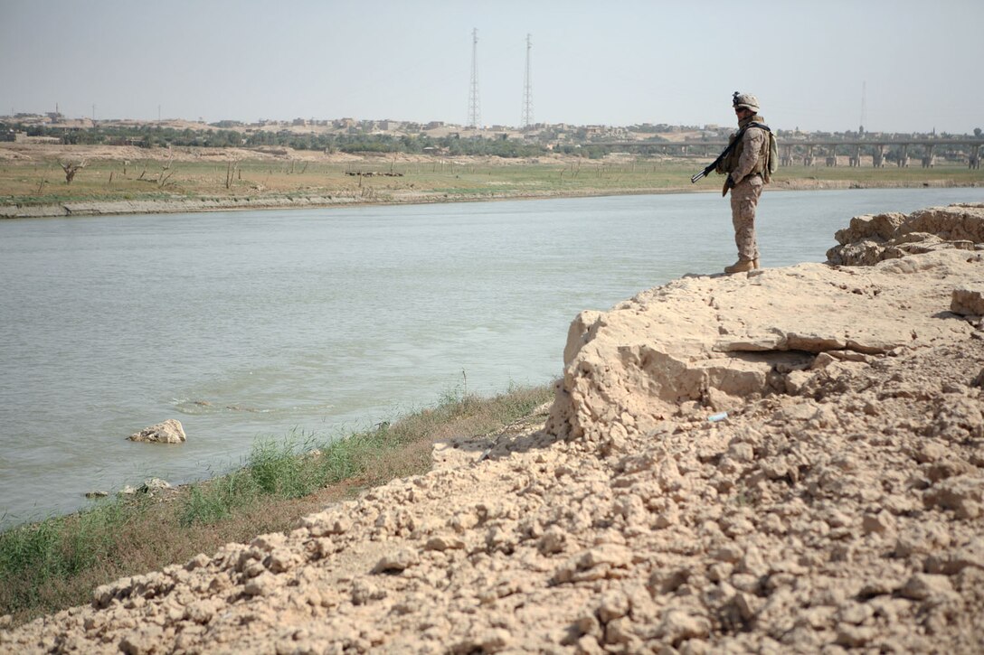 Staff Sgt. James M. Peyton, platoon commander, 1st Platoon, Fox Company, 2nd Battalion, 2nd Marine Regiment, Regimental Combat Team 5, overlooks the Euphrates River near Rawah, Iraq, from a point on the south bank of the river Oct. 14, a view he saw many times during six months his platoon conducted operational security at Traffic Control Points 3 and 4.  After handing over the TCPs to Provisional Rifle Platoon 3, RCT-5, the Fox Co. platoon returned to Combat Outpost Rawah.::r::::n::