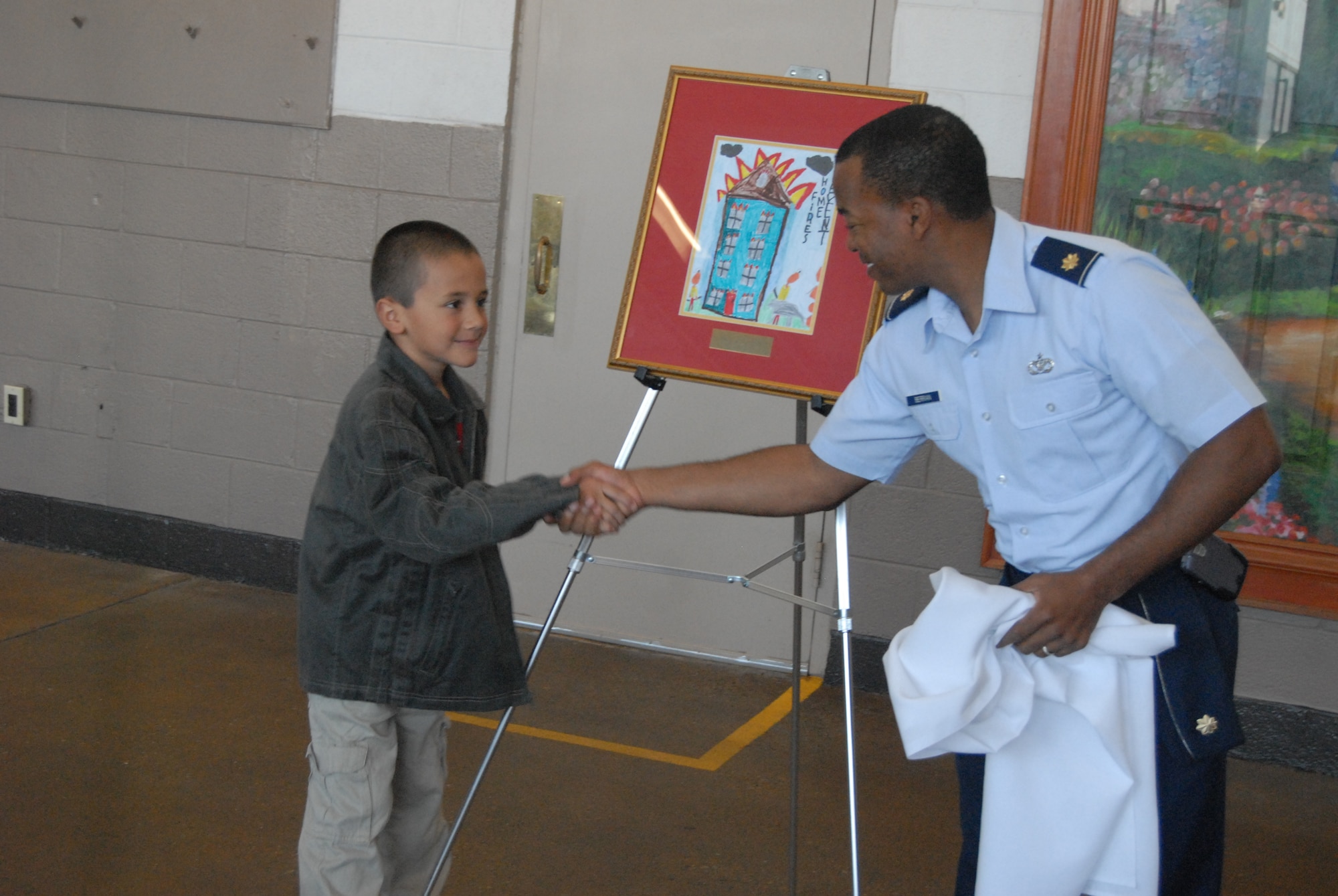 Isaiah Bailey, 7, shakes hands with Maj. Frederick Berrian, 43rd Civil Engineer Squadron Commander, at the opening ceremony of Fire Prevention Week Monday. Isaiah’s Fire Prevention Week poster won first place out of almost 100 entrants. This year’s Fire Prevention Awareness drive is titled “Prevent Home Fires” and will run through tomorrow. (U.S. Air Force Photo by Staff Sgt. Jon LaDue)