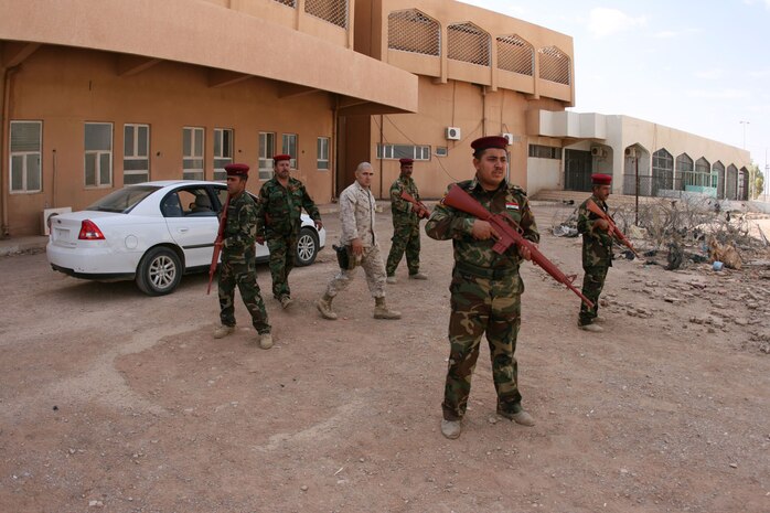 Under the mentorship of Staff Sgt. Anthony Macias (center), 33, of Corpus Christi, Texas, Iraqi commandos practice setting up a perimeter security during a personal security detail training exercise Oct. 13 at the Port of Trebil, Iraq.  Macias is a member of the Marine Corps' Port of Entry Transition Team at Trebil, which is located on the western fringe of Iraq's al-Anbar province.::r::::n::
