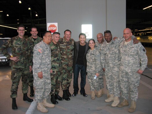 Actor Shia LaBeouf (center), takes a quick snapshot with Team March Airmen and Soldiers at DHL in January. More than 30 members from March participated in last weekend’s box office hit “Eagle Eye” during its filming at March ARB. Airmen, Soldiers, civilian employees and employees at the DHL distribution center at the south end of the base were all involved in various scenes. The DHL hub was used for a chase scene where the actors slid down and crawled across equipment, while military members participated as extras, posing as TSA and airport police. A C-17 aircraft was also featured. In the movie, LaBeouf and co-star Michelle Monaghan are strangers thrown together in dangerous situations after they receive a phone call by a mysterious woman who threatens their lives and their families. Throughout their travels, they are watched through everyday technology and are eventually marked as terrorists who become the most wanted people in the country. (U.S. Air Force photo) 
