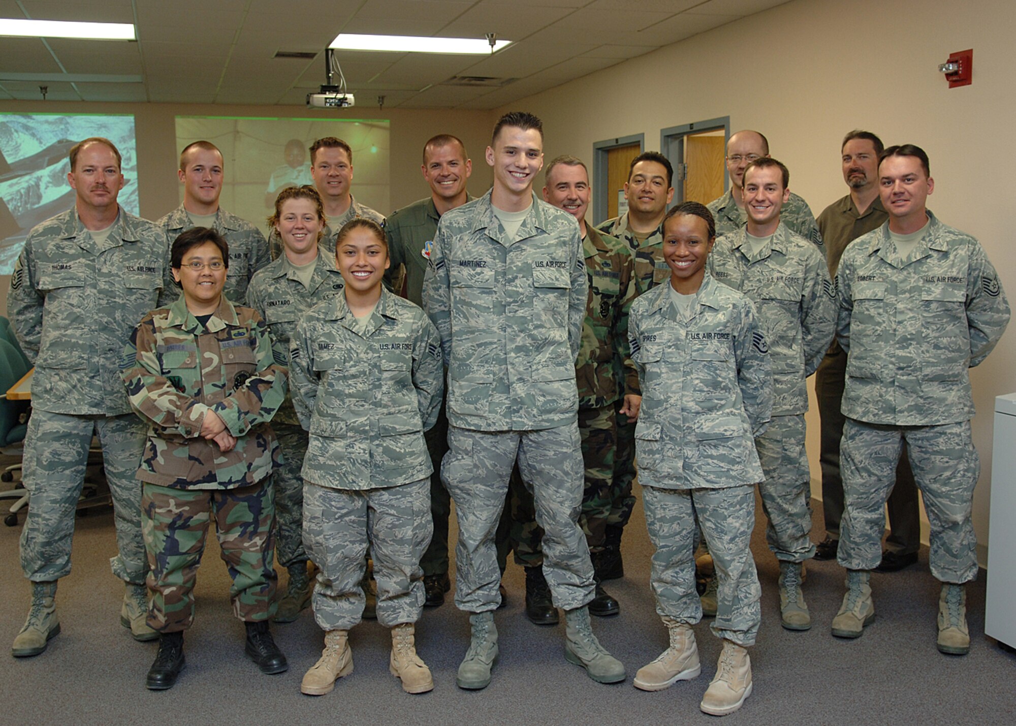 Recently deployed Airmen from 49th Logistics Readiness Squadron, Staff Sgt. Tamea Spires, Senior Airman Corina Gamez and Airman 1st Class Richard Martinez, pose for a group photo with Col. Michael McGee, 49th Fighter Wing vice commander and other members of the 49th LRS.  Sergeant Spires, Airmen Gamez, Martinez were deployed to Qatar for four months.  (U.S. Air Force photo by Airman 1st Class John D. Strong II)