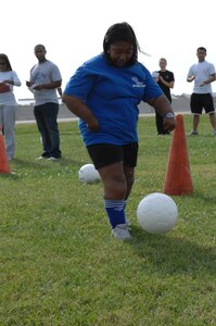LANGLEY AIR FORCE BASE, Va. -- Erica Johnson, daughter of Senior Master Sgt. Gerald Johnson Air Combat Command fire emergency services inspector, kicks a soccer ball during a soccer skills competition, part of Special Olympics held here Oct. 11. Erica has competed in Special Olympics events since 2003. (U.S. Air Force Photo/Tech. Sgt. April Wickes)