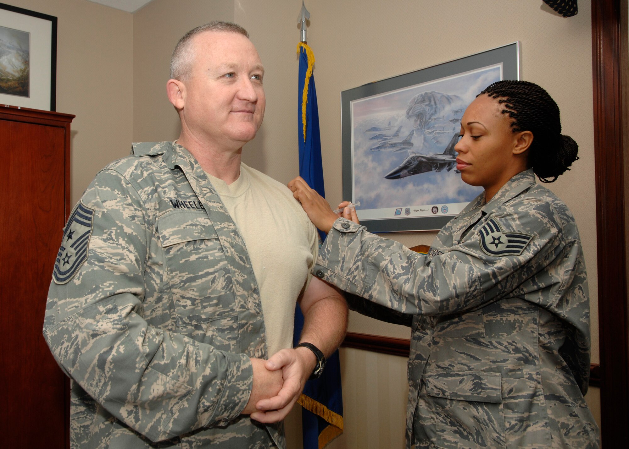 Chief Master Sgt. Paul Wheeler, Air Force District of Washington command chief, receives his flu shot from Aerospace Medical Technician Staff Sgt. Latoya McGee, from the 779th Medical Operation Squadron, Allergy/Immunization Clinic, Andrews Air Force Base, Md. Flu vaccinations this year are being combined with Individual Medical Readiness screenings for all AFDW Airmen assigned to Andrews. Screenings will occur Oct. 21 thru 23 from 7 a.m. to 7 p.m. at the Andrews base theater. In addition to the flu vaccination, public health, dental and immunizations readiness requirements  will be reviewed. Flu shots are recommended for all Airmen. According to the Centers for Disease Control and Prevention, each year in the United States more than 200,000 people are hospitalized and more than 36,000 people die from flu complications.