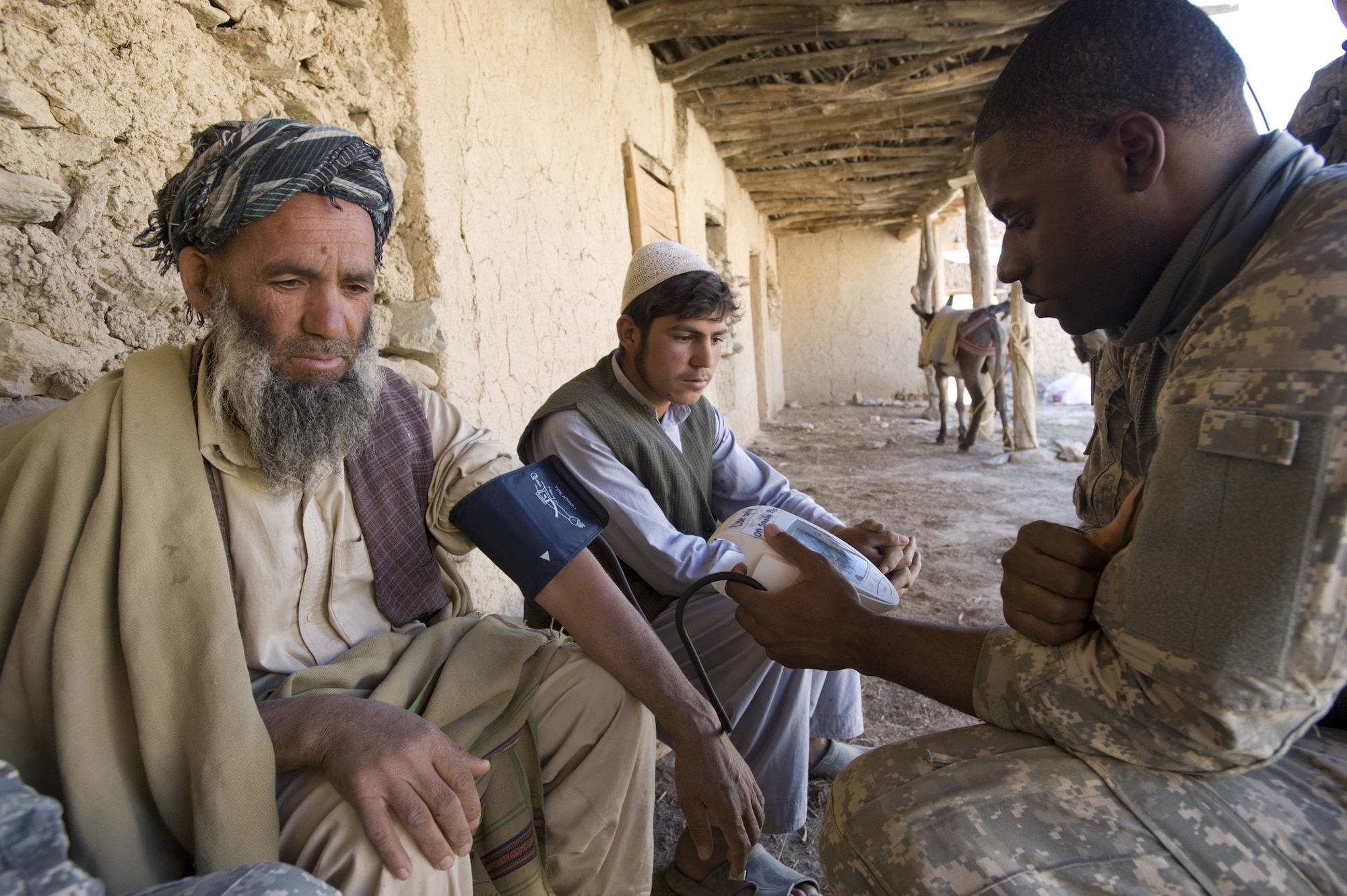 Senior Airman Courtney Thompson examines an Afghan man at a village medical outreach clinic in the small, mountainous village of Pacha Hawk, Afghanistan. The event, two months in the making, brought a 40-person, joint-service team to the remote, mountain-top village. Airman Thompson is a Kapisa and Parwan Provincial Reconstruction Team medic. (U.S. Air Force photo/Master Sgt. Keith Brown) 
