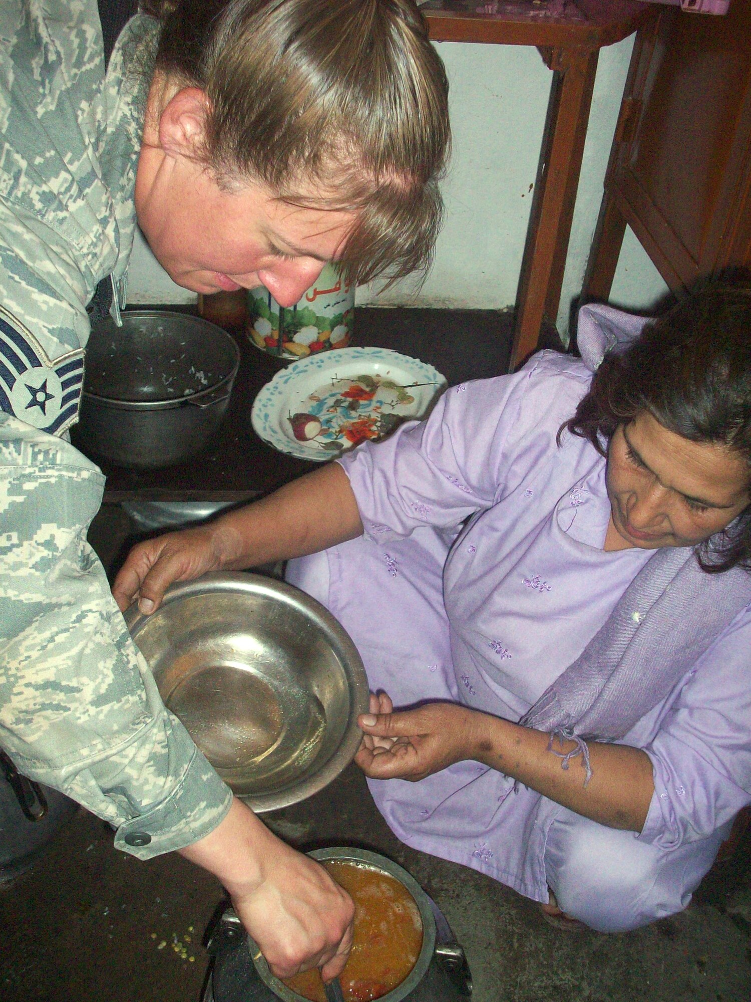 Staff Sgt. Michelle Cooper helps to prepare a special meal. Miriam Panjshiri, director of women's affairs for Afghanistan's Panjshir province, and her sister, Nasrene, hosted the PRT's affairs team for a time of fellowship and an Afghan cooking class Oct. 2. Sergeant Cooper is the services superintendent for the Panjshir Provincial Reconstruction Team. (U.S. Army photo)
