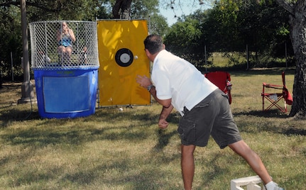 Master Sgt. Monica Nicholson, 12th Medical Group first sergeant, holds her nose as Airmen try to send her swimming in the dunk tank at Ocktoberfest 2008. Airmen, coworkers, family members and supervisors spent the day celebrating enlisted Airmen for their contributions to the Air Force and Nation. (U.S. Air Force photo by Rich McFadden)
