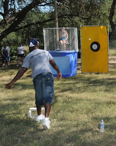Master Sgt. Monica Nicolson, 12th Medical Group first sergeant, holds her nose as Airmen throw to send her swimming in the dunk tank at Ocktoberfest 2008. Airmen, coworkers, family members and supervisors spent the day celebrating enlisted Airmen for their contributions to the Air Force and Nation. (U.S. Air Force photo by Rich McFadden)