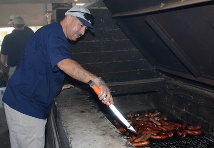 Chief Master Sgt. Ron Gallegos, 12th Mission Support Group, flips bratwurst at Ocktoberfest 2008. Airmen, coworkers, family members and supervisors spent the day celebrating enlisted Airmen for their contributions to the Air Force and Nation. (U.S. Air Force photo by Rich McFadden)