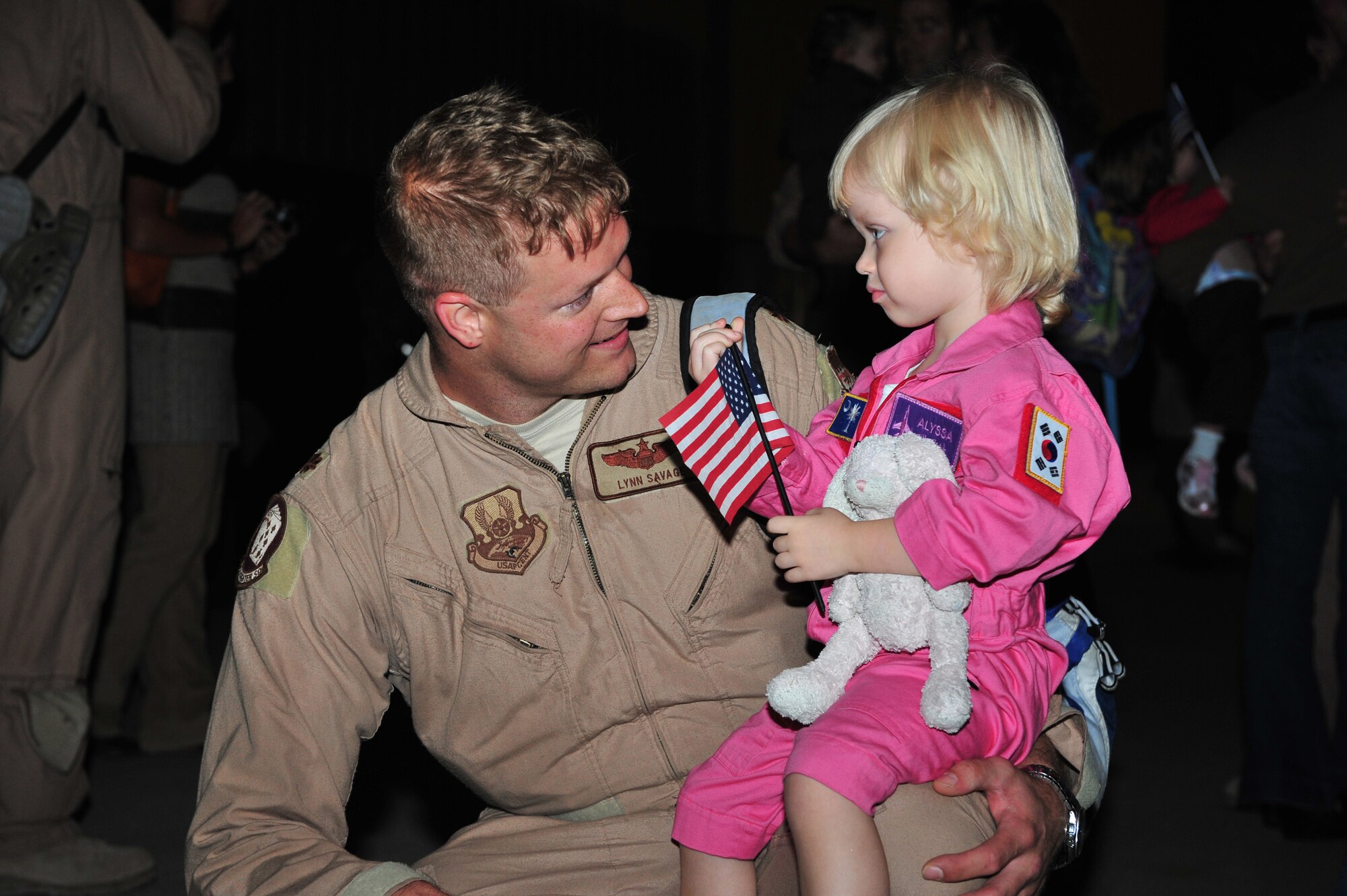 SHAW AIR FORCE BASE, S.C. --  Maj. Lynn Savage, 77th Fighter Squadron, holds his daughter Alyssa Oct. 13 after returning from a four-month deployment to Southwest Asia along with approximately 340 other Airmen. The Airmen supported the 77th Fighter Squadron and its pilots during the deployment. (U.S. Air Force photo/Tech. Sgt. Josef Cole)